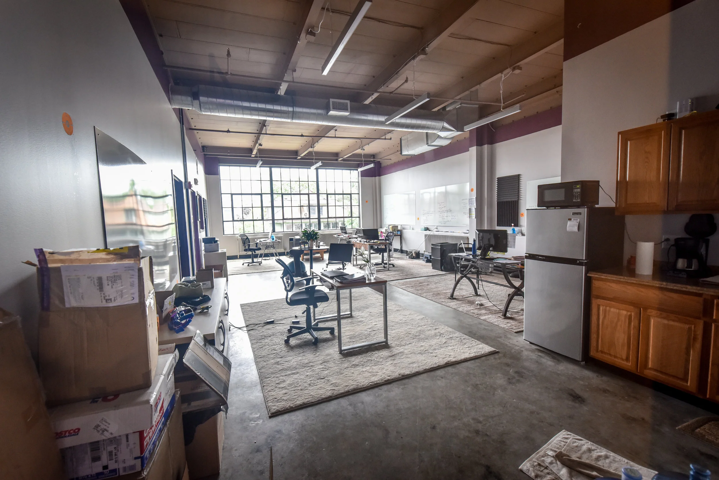 Large open room with kitchen area, desk, dining area, and sitting area.