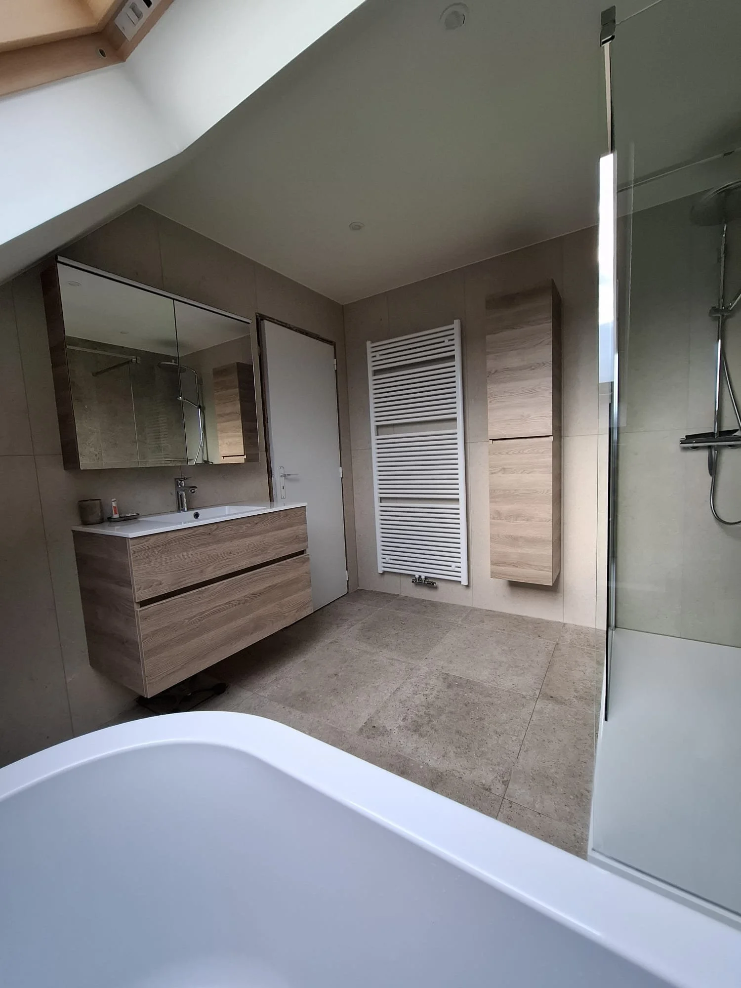 Moderne badkamer met wastafel, spiegelkast, radiatorkachel en inloopdouche.