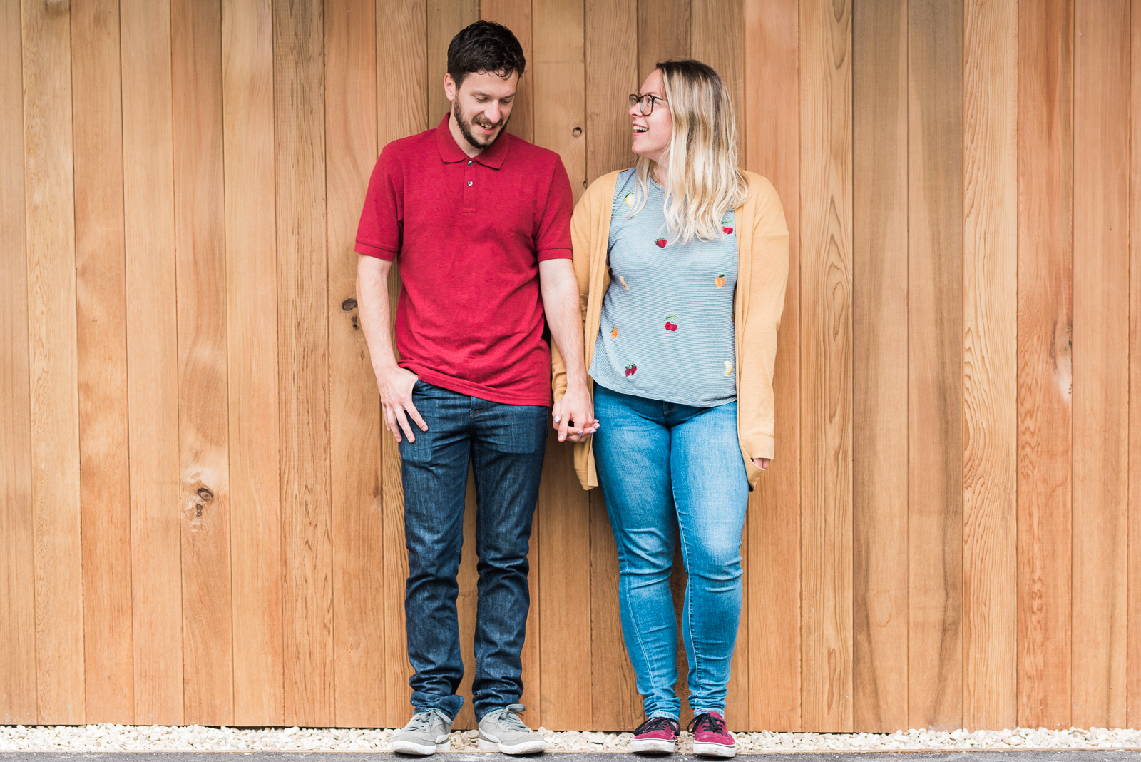 Couple stood against wooden backdrop holding hands - Cotswolds Wedding Photographer