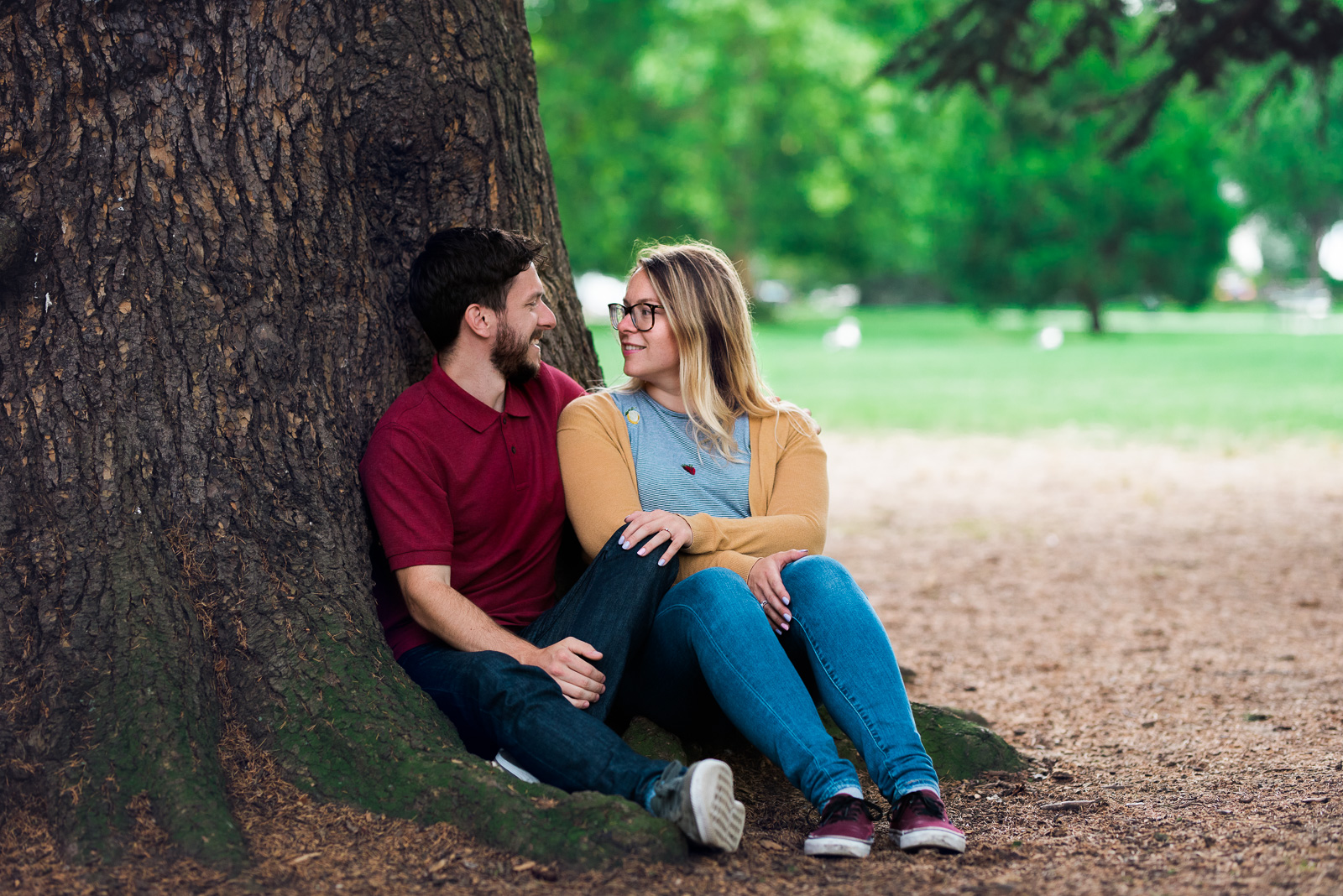 Cuddling by a tree in the park - Cotswolds Wedding Photographer
