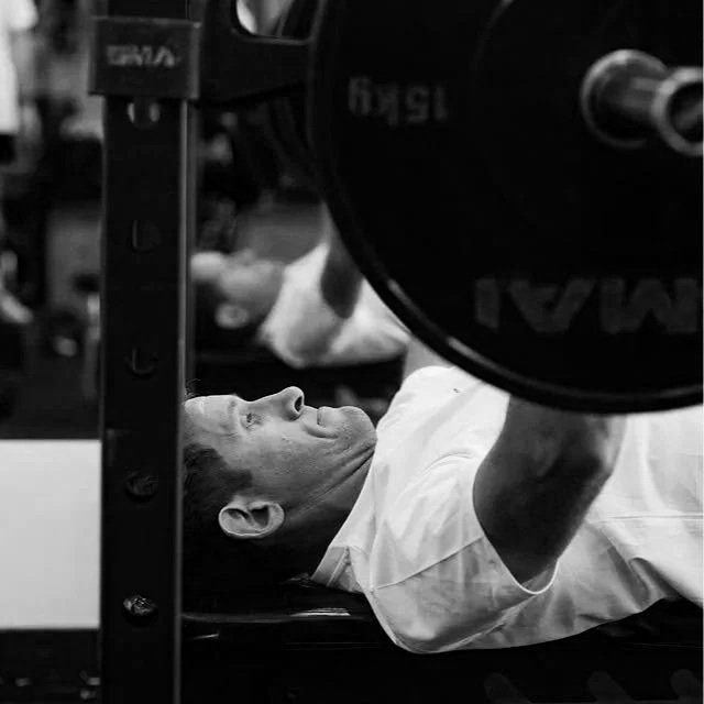 Man performing a barbell bench press during personal training at a gym in Edgecliff, near Paddington in Sydney’s Eastern Suburbs.