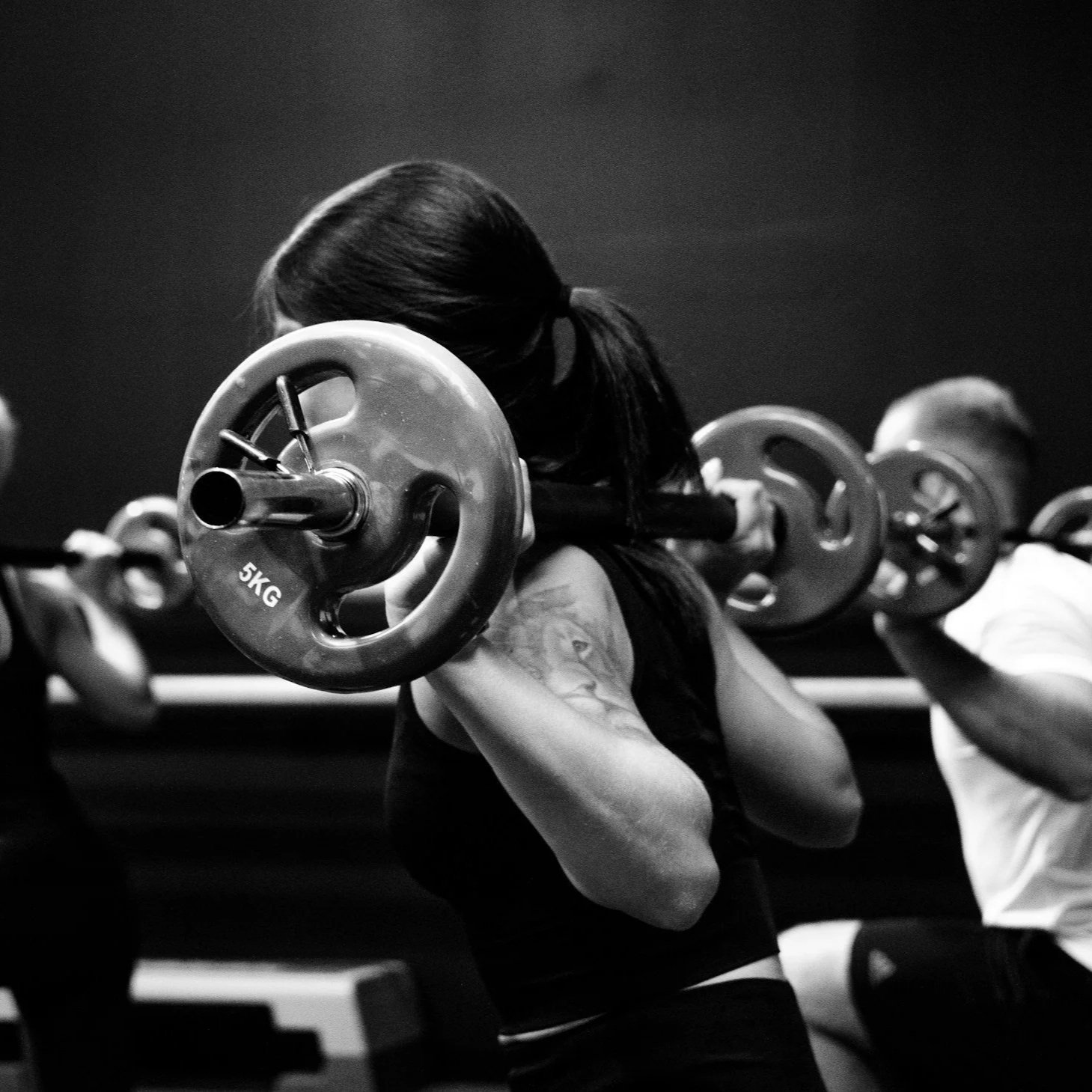 Woman performing a barbell squat during a strength class at a gym in Edgecliff, near Paddington in Sydney’s Eastern Suburbs.