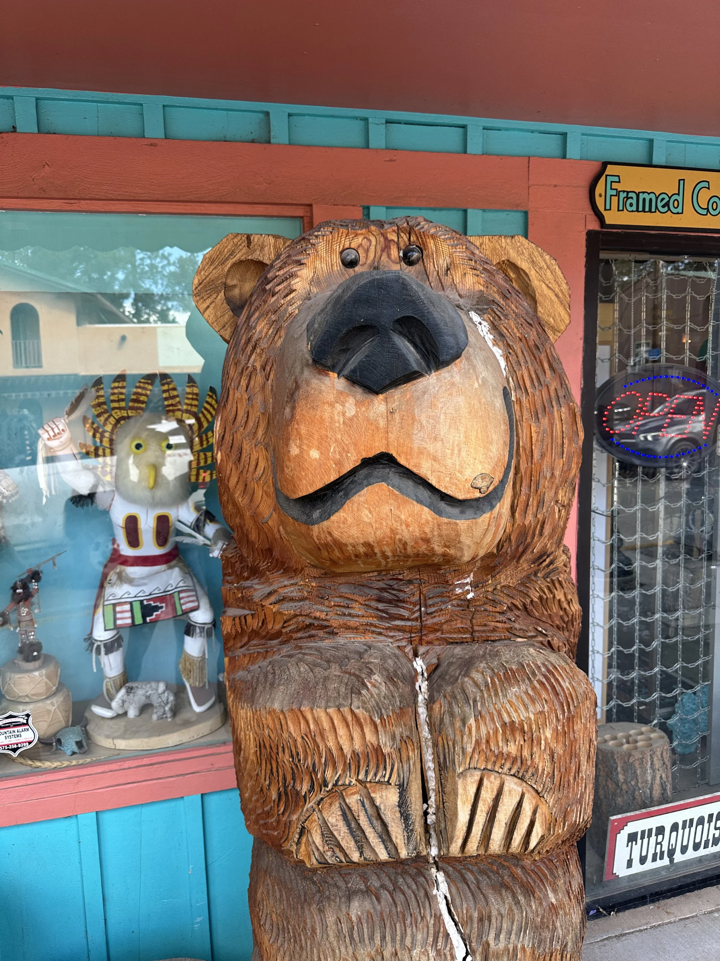  Carved wooden bear statue outside a colorful Ruidoso shop. 