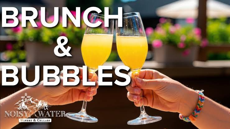 Two mimosa glasses clink in front of a sunny patio with “Brunch & Bubbles” and Noisy Water Winery branding.