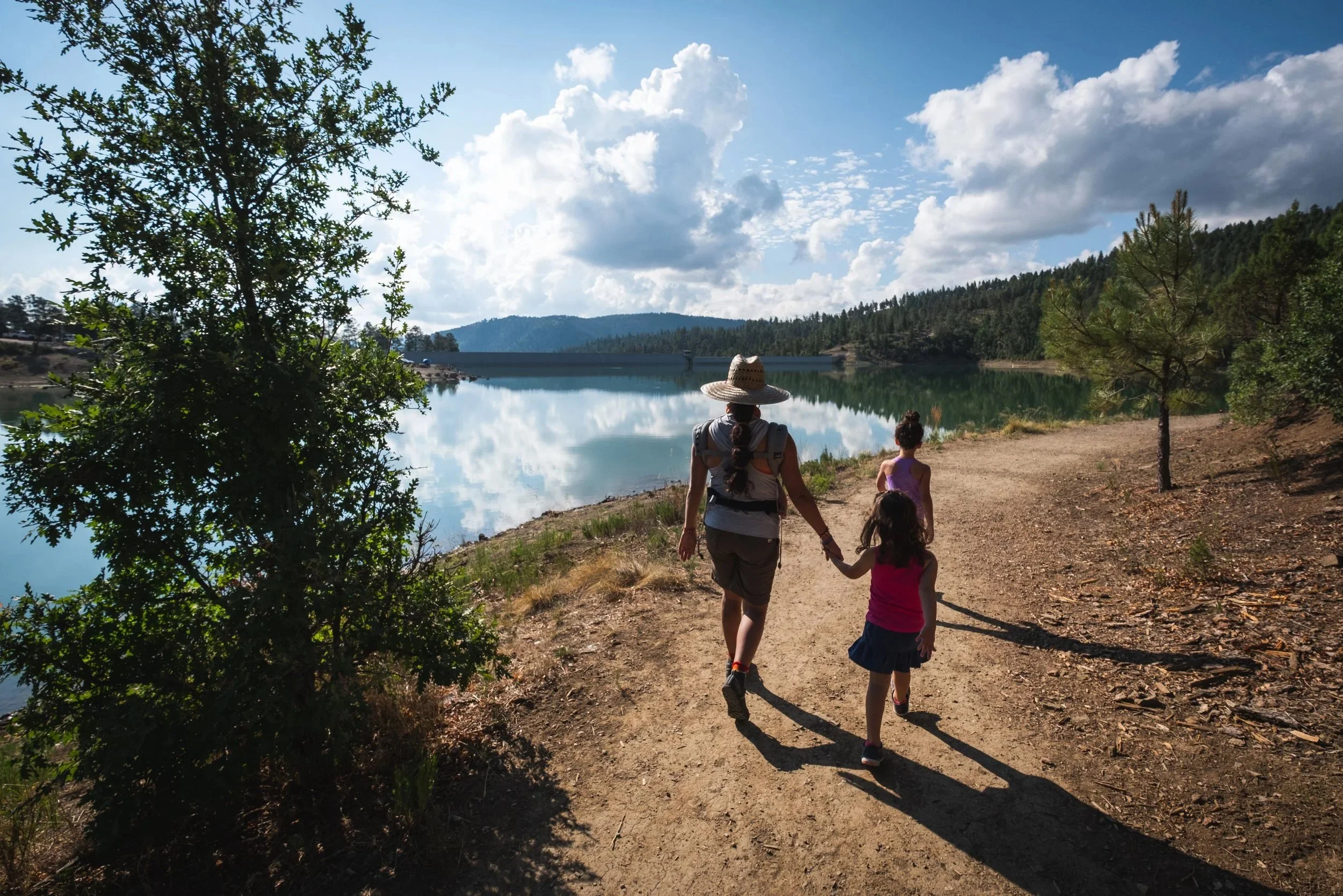 Visitors walking a lakeside trail at Grindstone Lake in Ruidoso, New Mexico