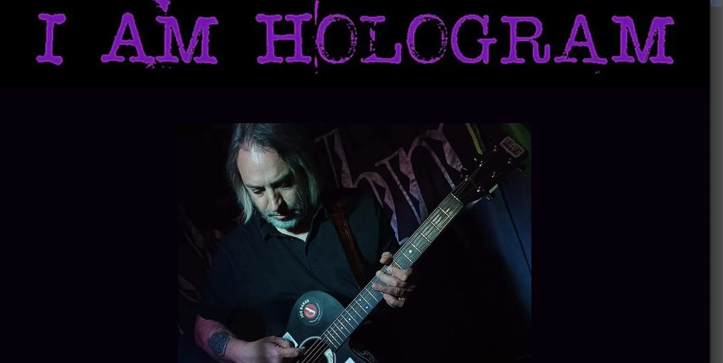 Promotional graphic for I Am Hologram featuring a musician playing acoustic guitar under dark stage lighting with large purple “I AM HOLOGRAM” text across the top against a black background.