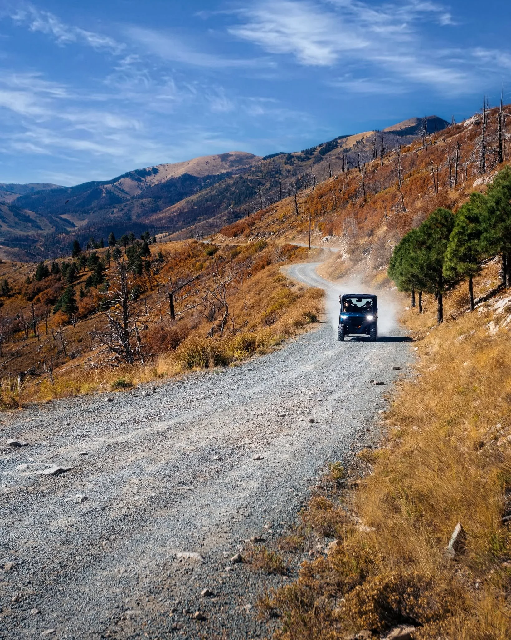 OHV traveling a winding mountain road through autumn scenery near Ruidoso.