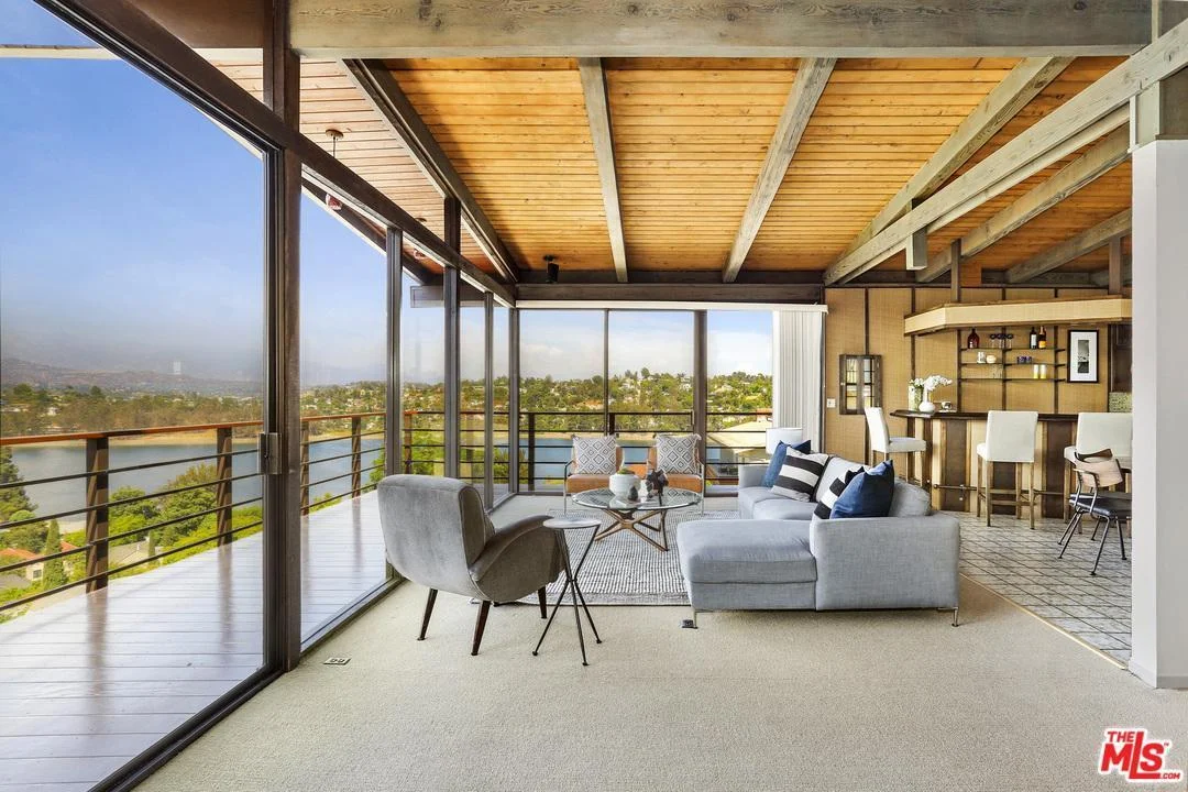 Perched atop one of Silver Lake's most coveted streets, The Pettibone Residence by J. G. Kitashima is a custom designed, single owner, architectural residence that brings the reservoir into the living room through floor to ceiling glass walls. Spectacular panoramic mountain and reservoir views spanning over 180 degrees. The home boasts an entertainer's floor plan with formal living and fireplace, dining room, bar and breakfast areas, cook's kitchen, 3 bedrooms and 2.5 baths. The master suite complete with over sized master bath, Japanese soaking tub, large dressing area and exterior reflecting balcony overlooking a Zen like koi pond and faux pagoda. The two additional bedrooms share a complete bath. The home has a maturely landscaped rear yard. The 2 car garage comes complete with an elevator to your grand entry. This address is also in the highly desired Ivanhoe School district, buyers to confirm eligibility for enrollment. Listing courtesy of Lori Ramirez, Coldwell Banker Residential Brokerage