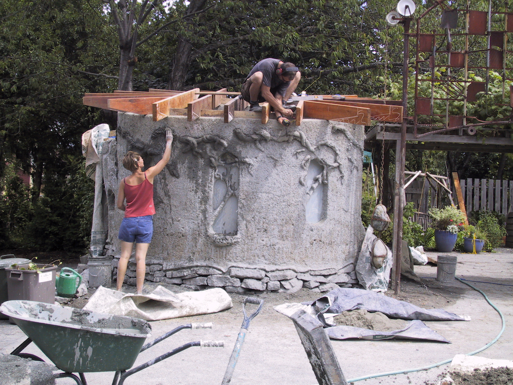 John Freeman works on the roof. Sculptress adds relief to the building.
