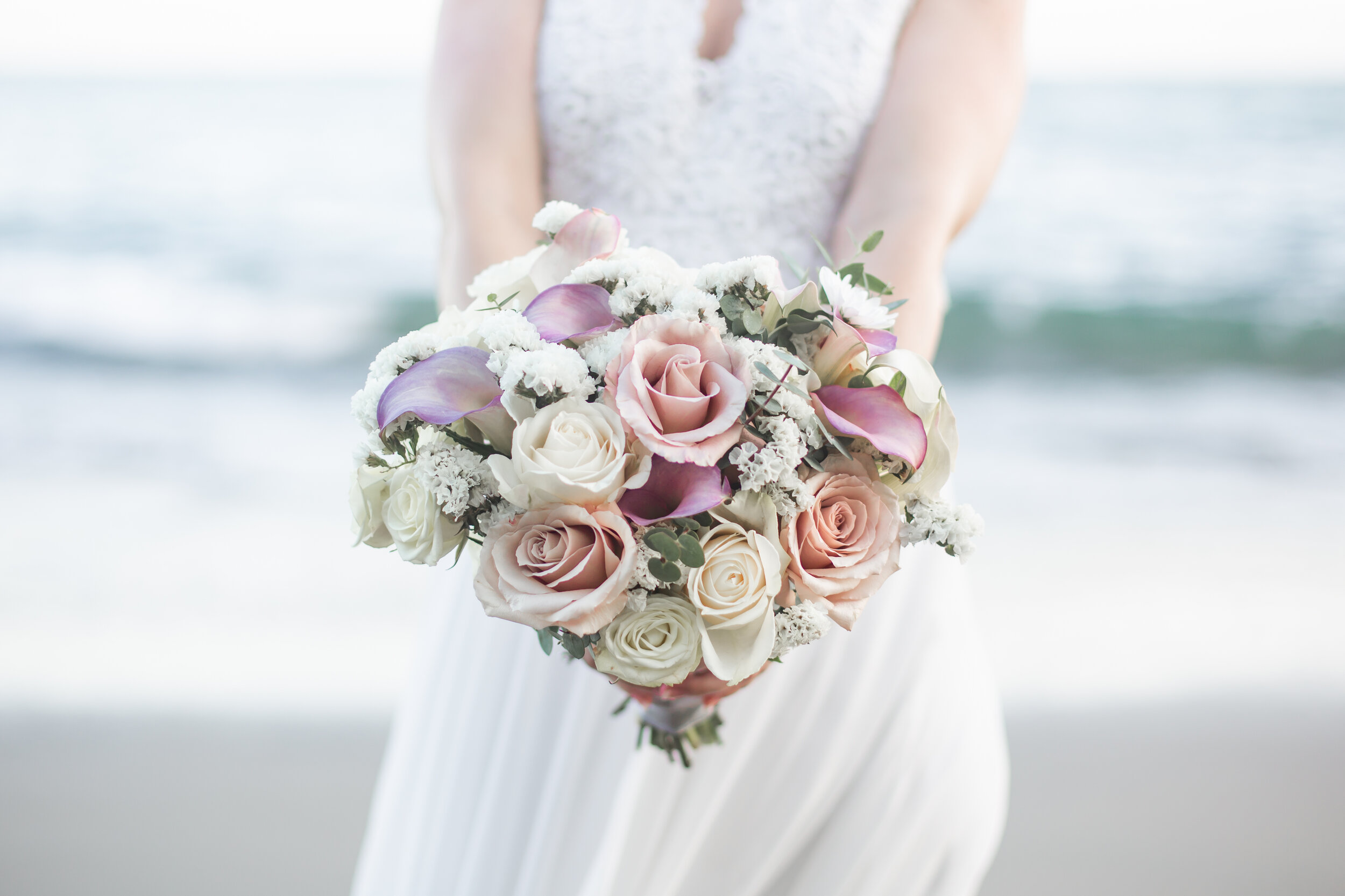  bride holding pink and white bouquet on the beach 