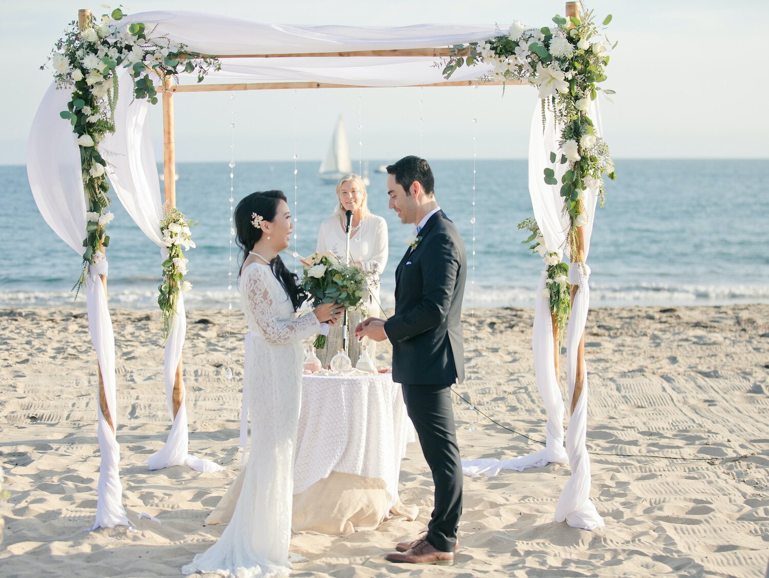  couple stand under chuppah on Santa Barbara beach 