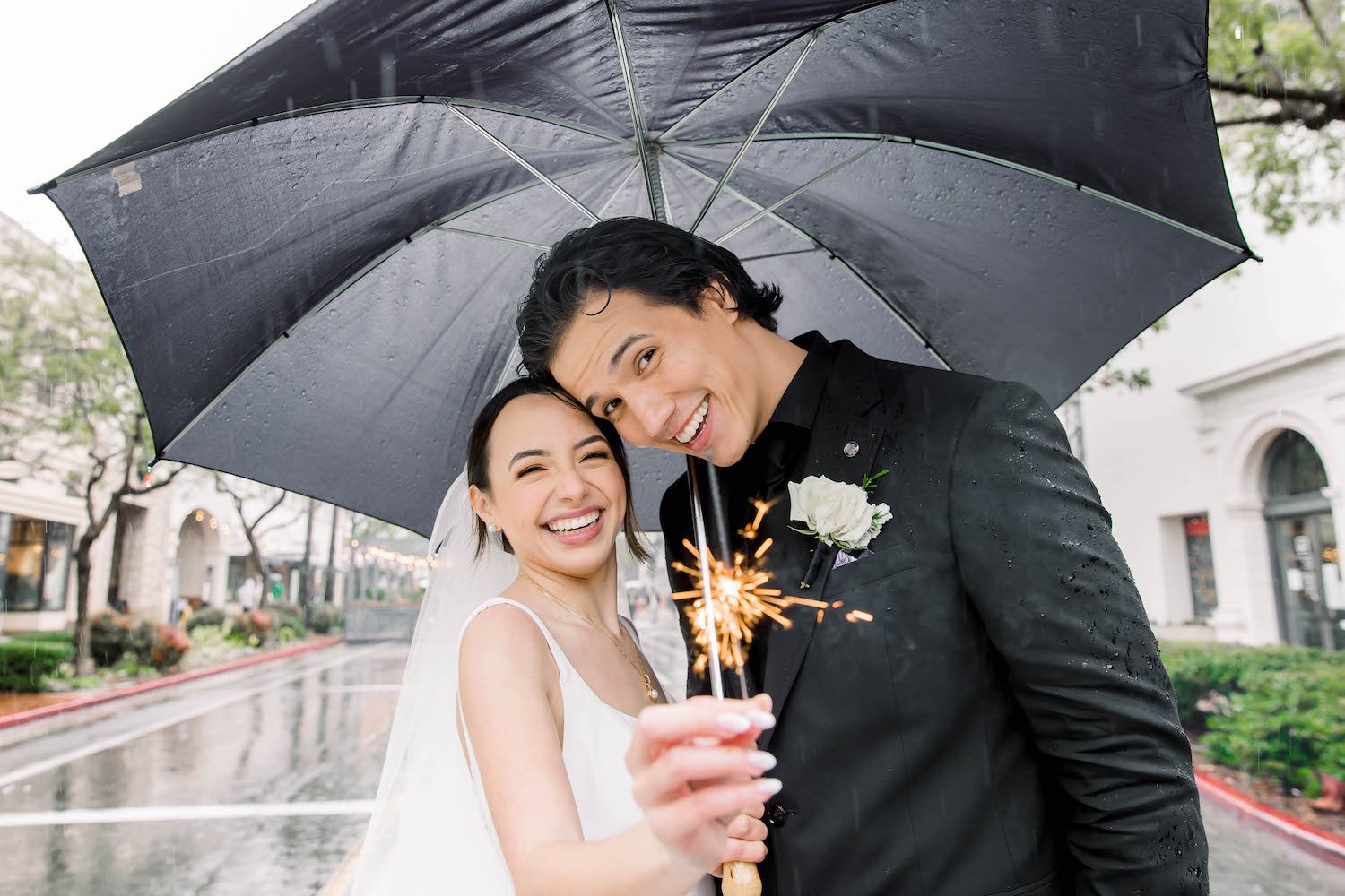  bride and groom standing umbrella in the rain in Santa Barbara 