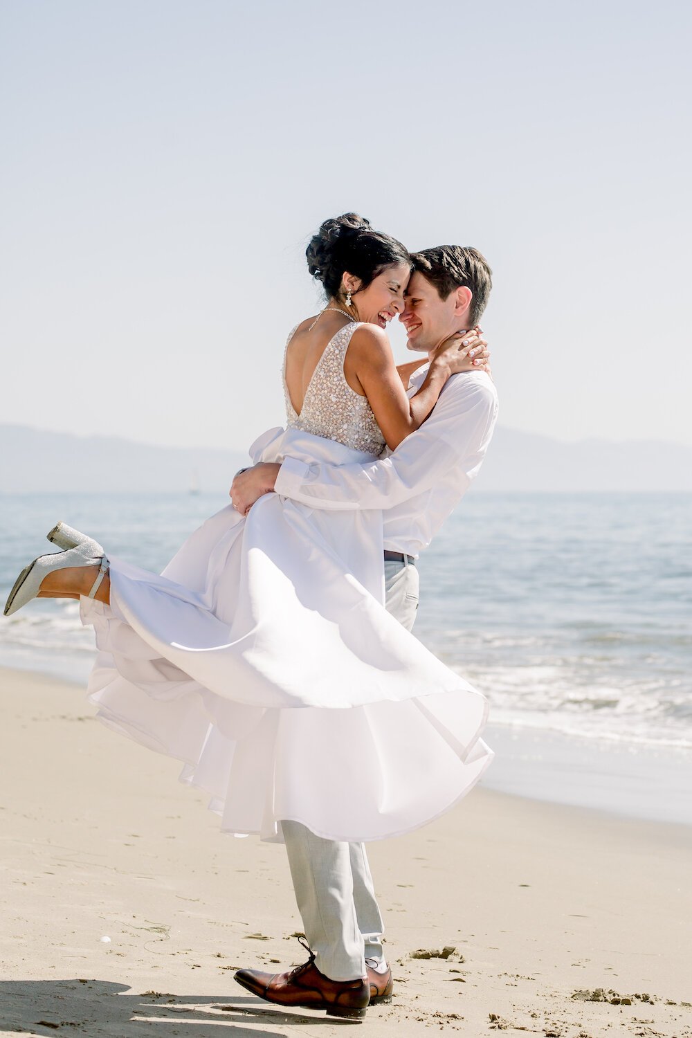 groom spins bride around in wedding dress