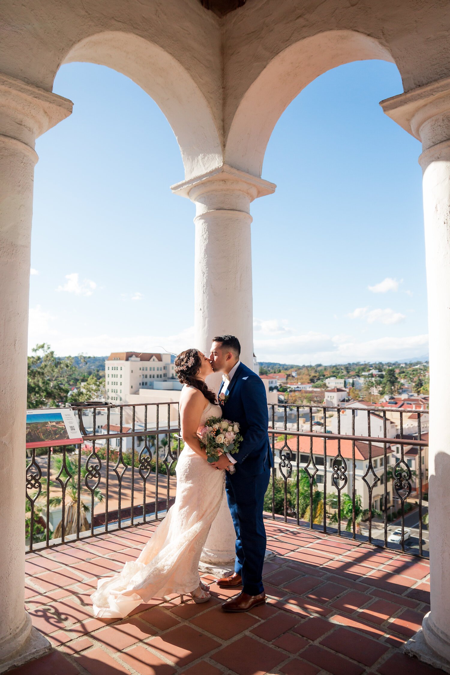 bride and groom kiss with Santa Barbara in background