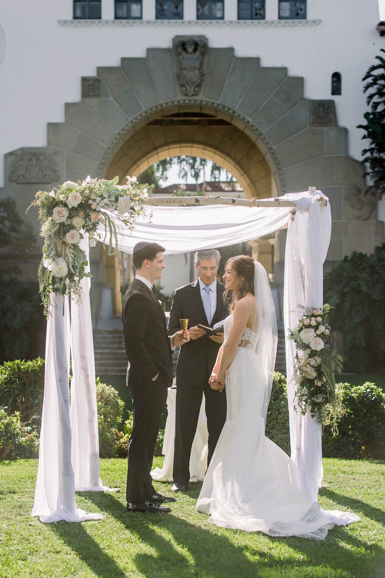 bride and groom under chuppah at wedding ceremony