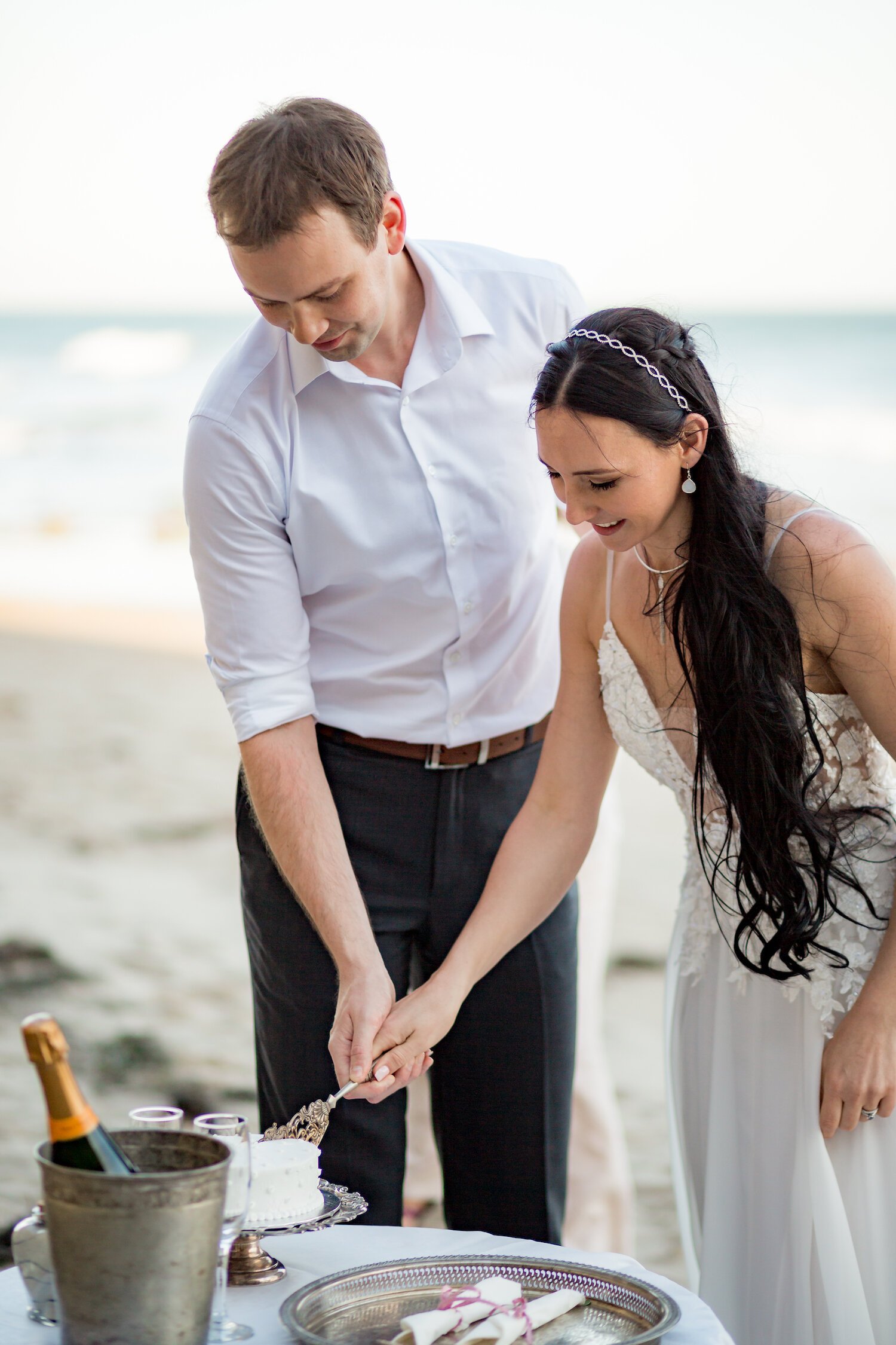 couple cut wedding cake on Santa Barbara beach