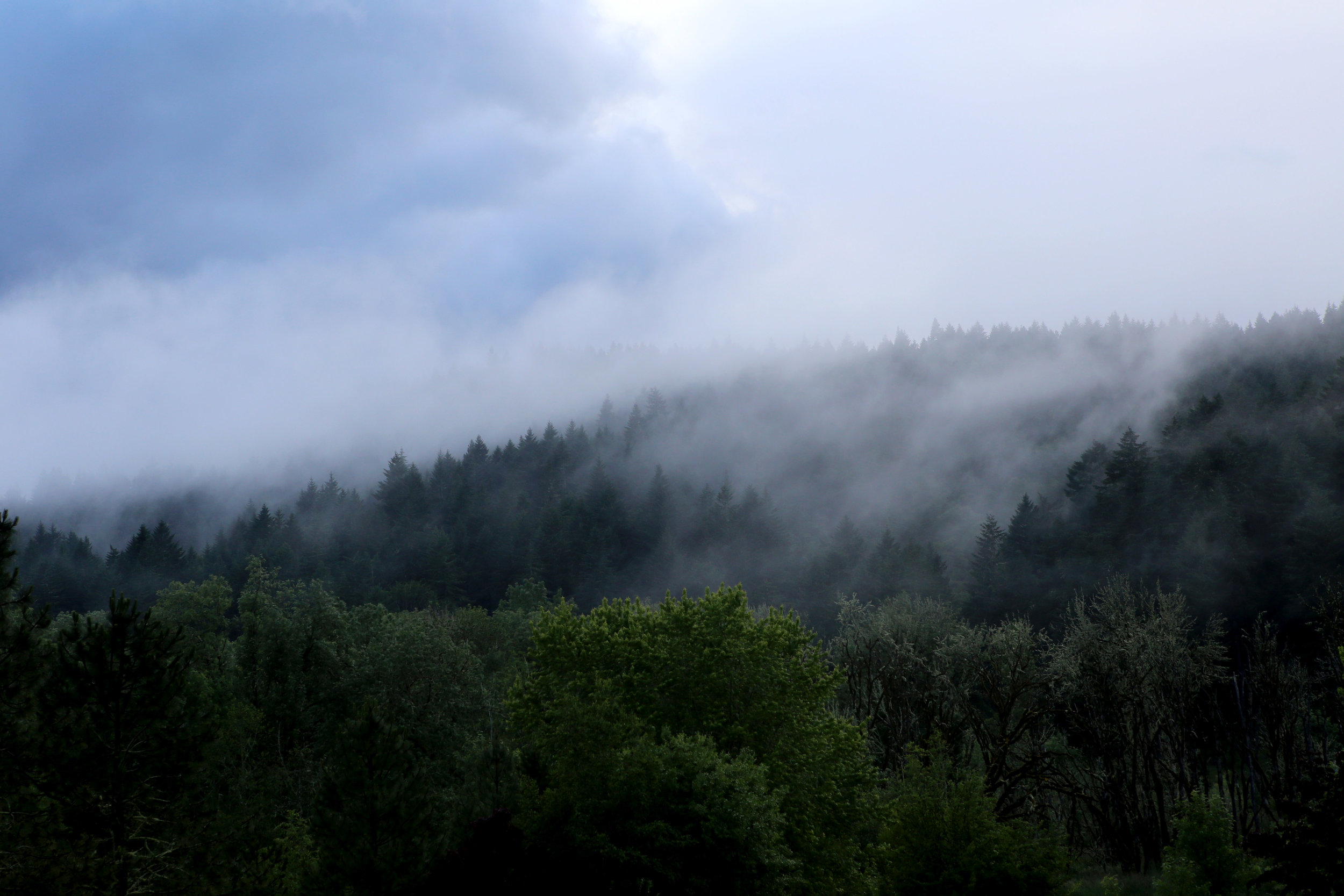 A storm rolls in the clouds hug the ridge