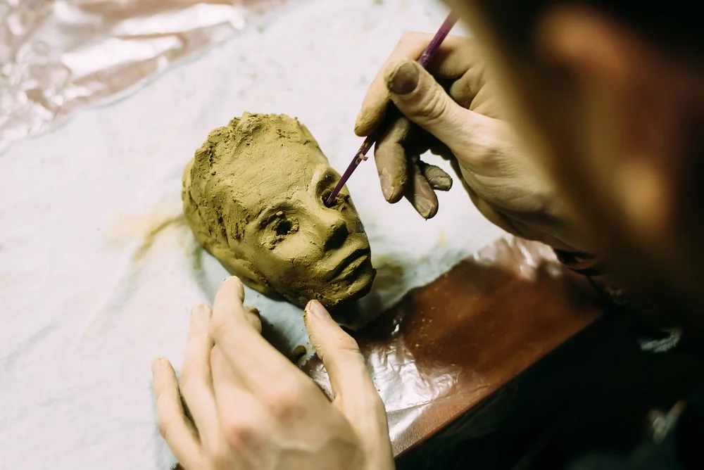 Person working with clay to create a person's head