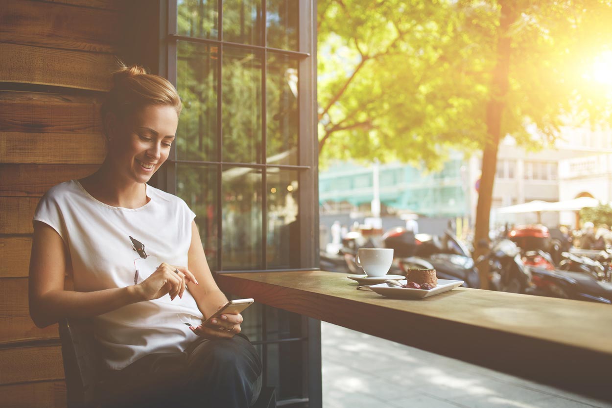 young-woman-happily-googling-affordable-web-design-denver-at-a-coffee-shop.jpg