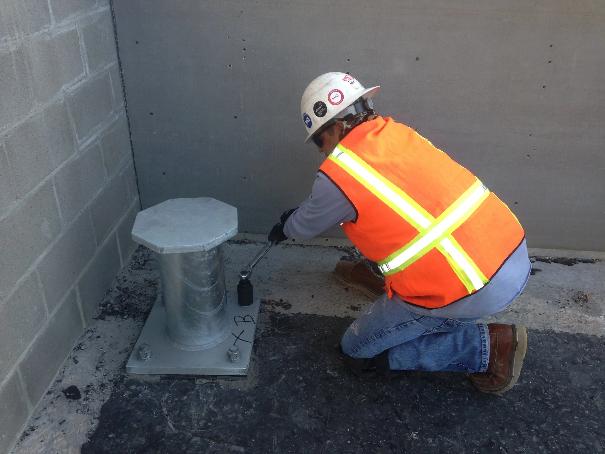 Step 4. Because the roof has a natural slope, all pedestals and tie-back devices were shimmed to keep the posts vertical and the pedestal plate level. Gaps will be filled with high strength grout prior to roofing.