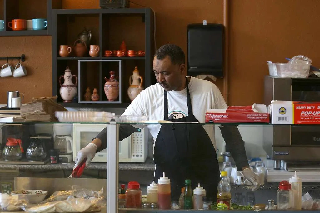 Aref Elgaali behind the counter at his Z Zoul Cafe in the Tenderloin. Photo by Liz Halifa, The Chronicle