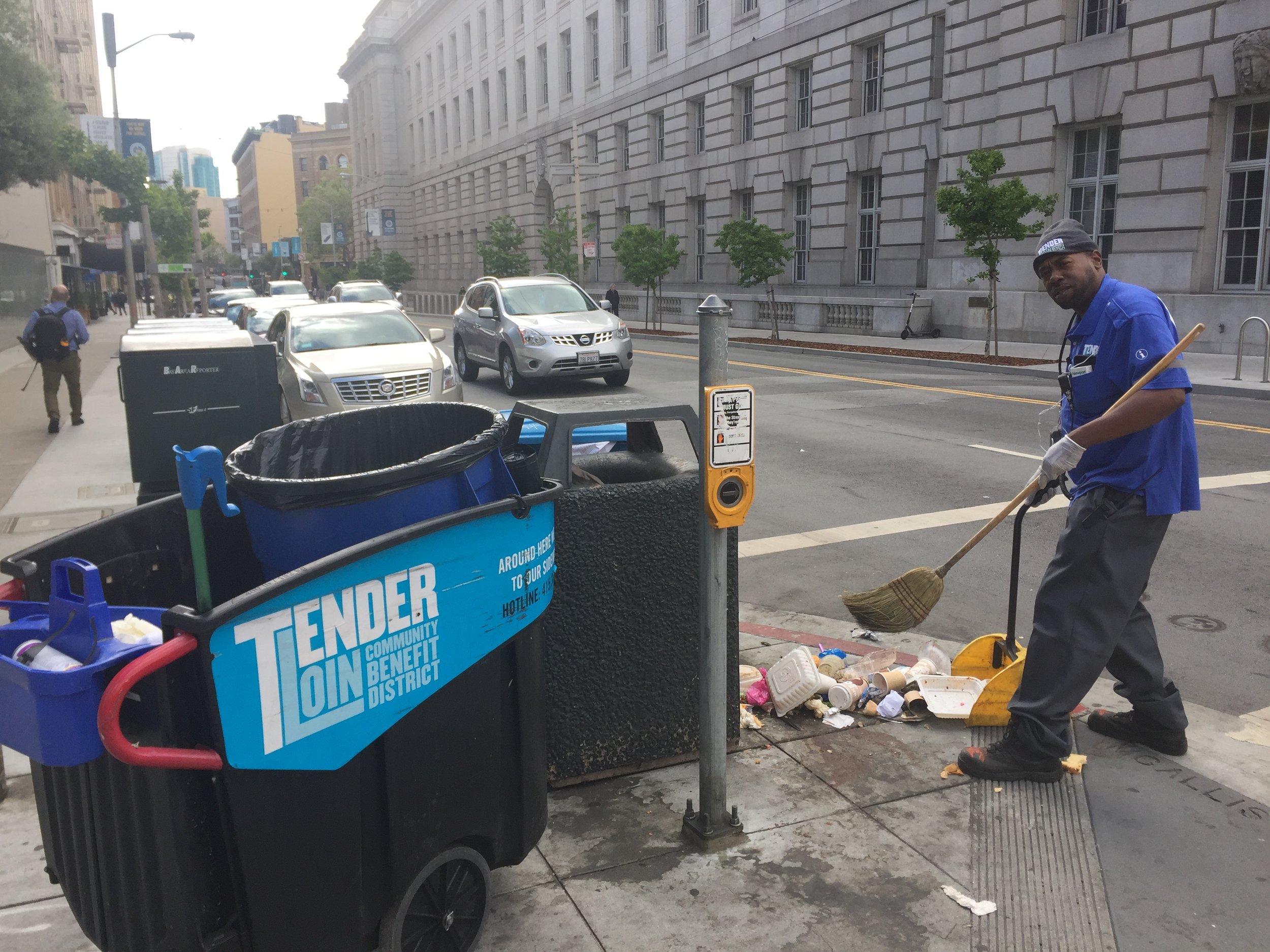 TLCBD Clean Team member, Maurice "Mo" Jackson, removes debris from an overturned trash can.