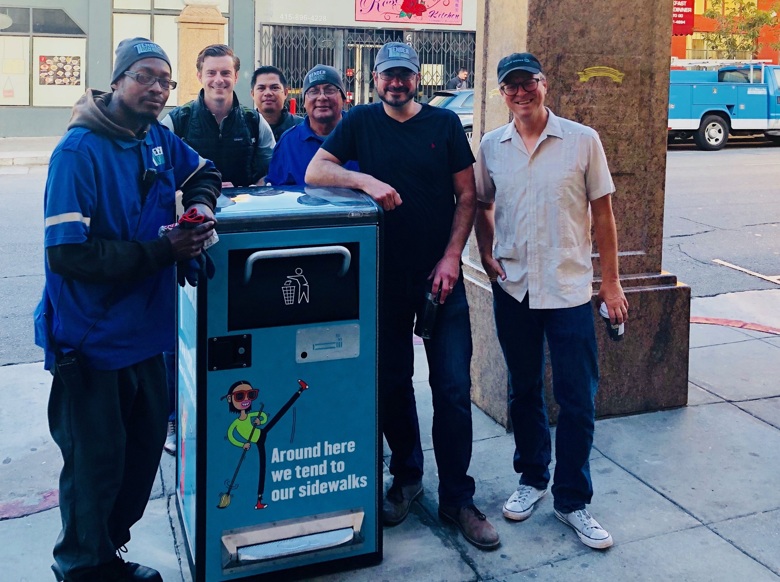 TLCBD staff and partners from Fix It Team and Big Belly company install a new trashcan at the gates of Little Saigon.