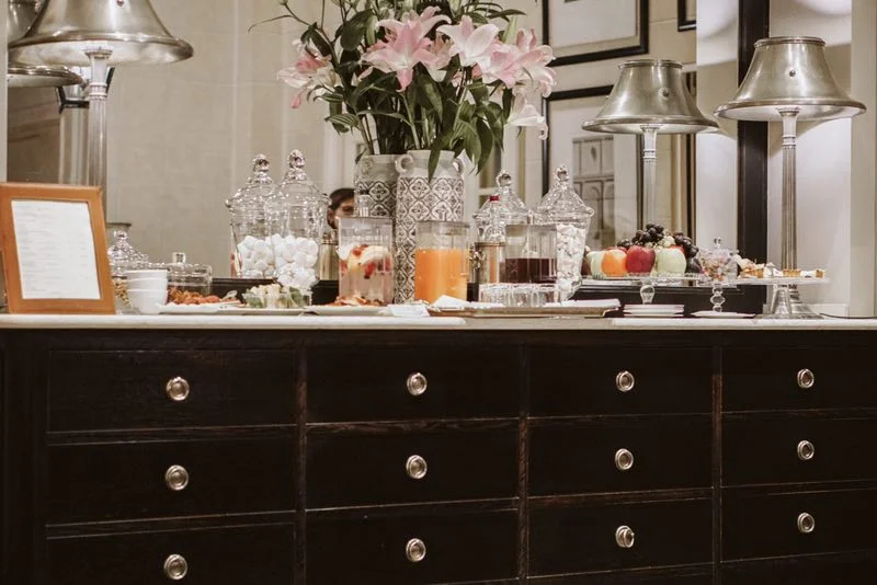 The beautiful sideboard is laid with jars of sweets, fresh fruits, home -made cakes , hot and cold drinks to which guests can help themselves.