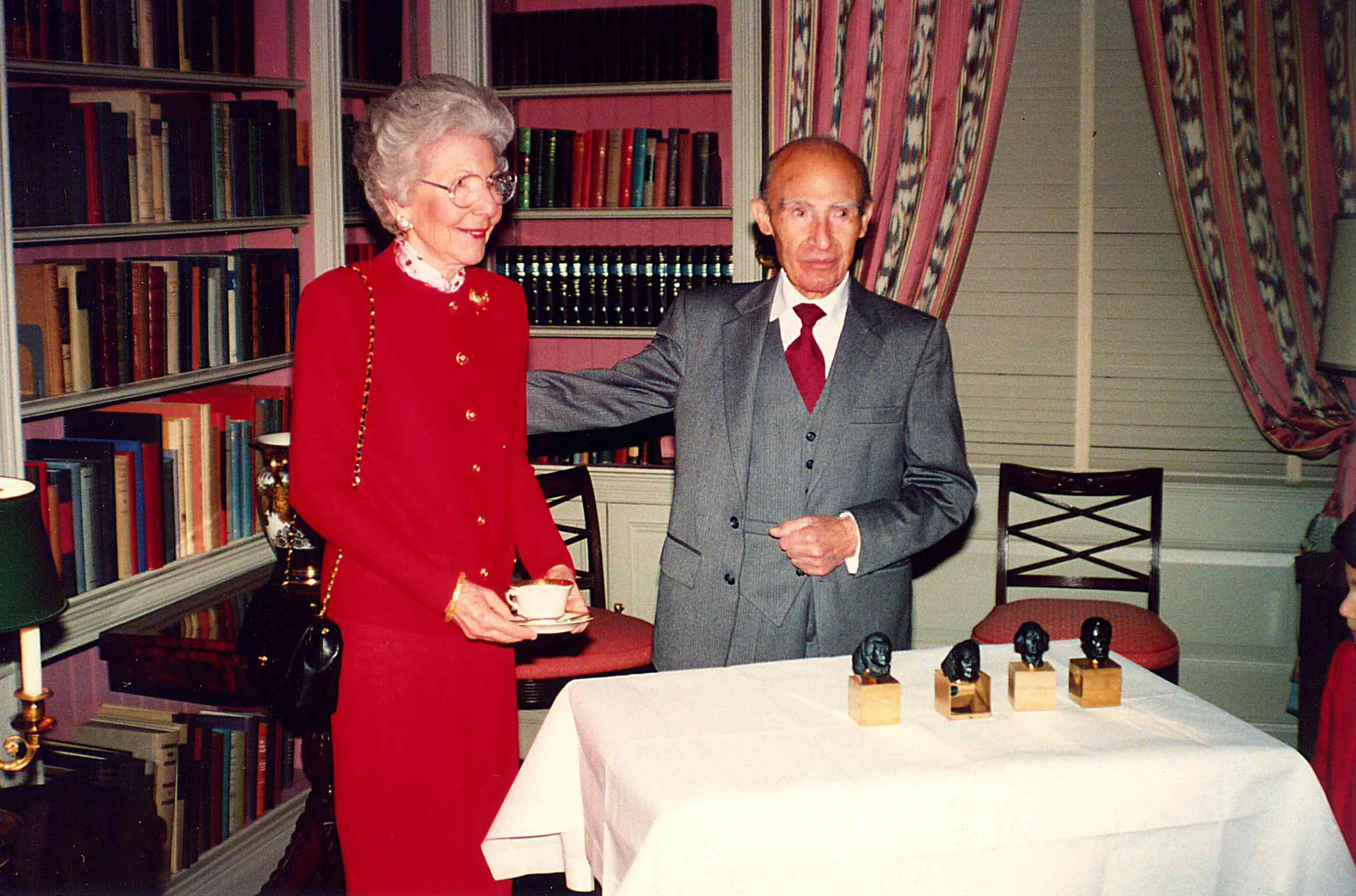 Rose and Harry Kazanjian standing behind the 4 Sapphire president heads in the White House during Ronald Regan's presidency.