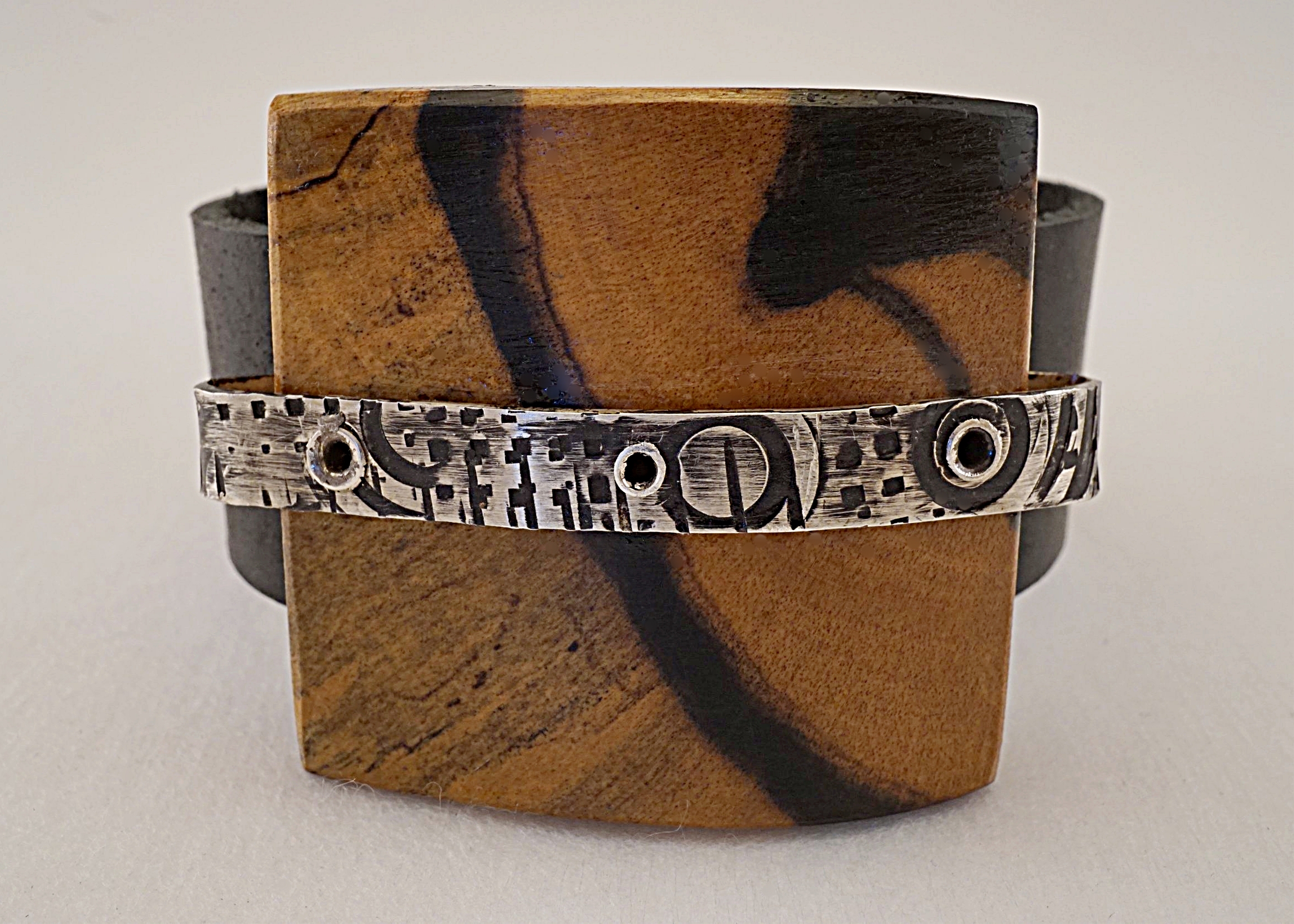 Hand carved black and white ebony wood with hand stamped sterling silver on black leather