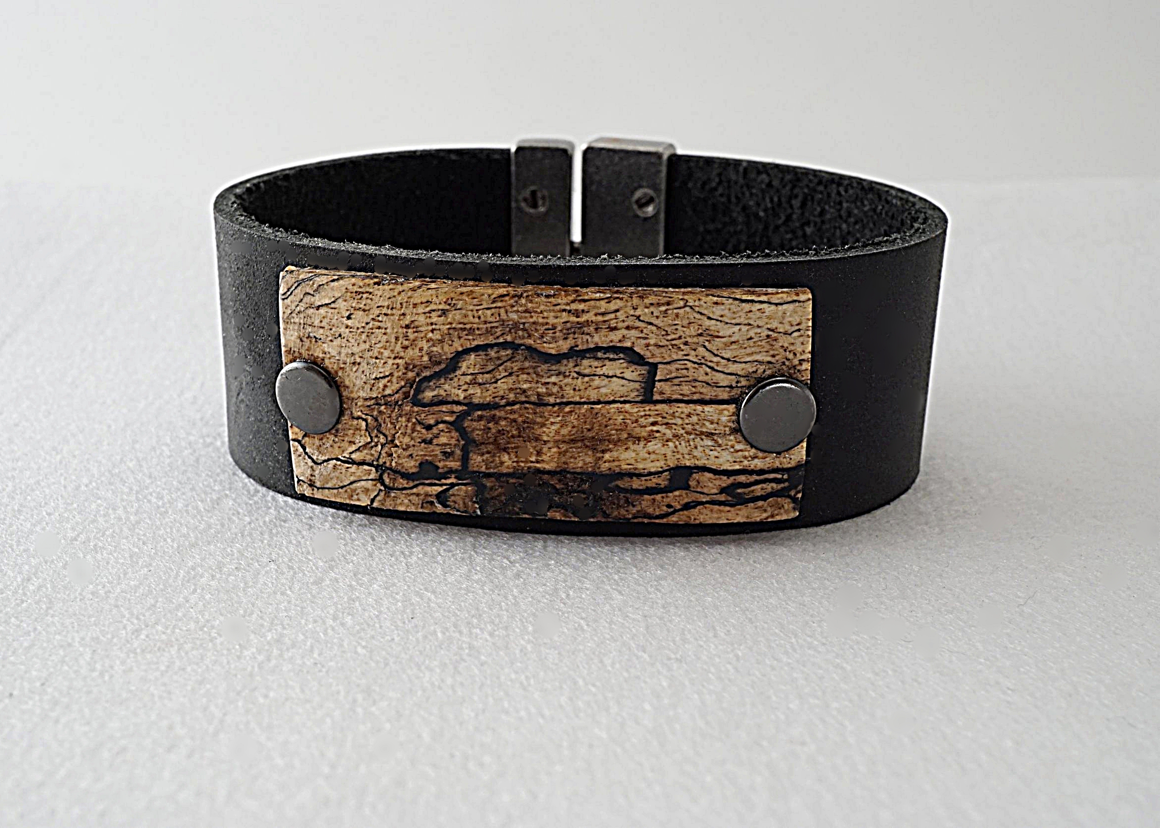Hand carved spalted tamarind wood riveted onto leather band