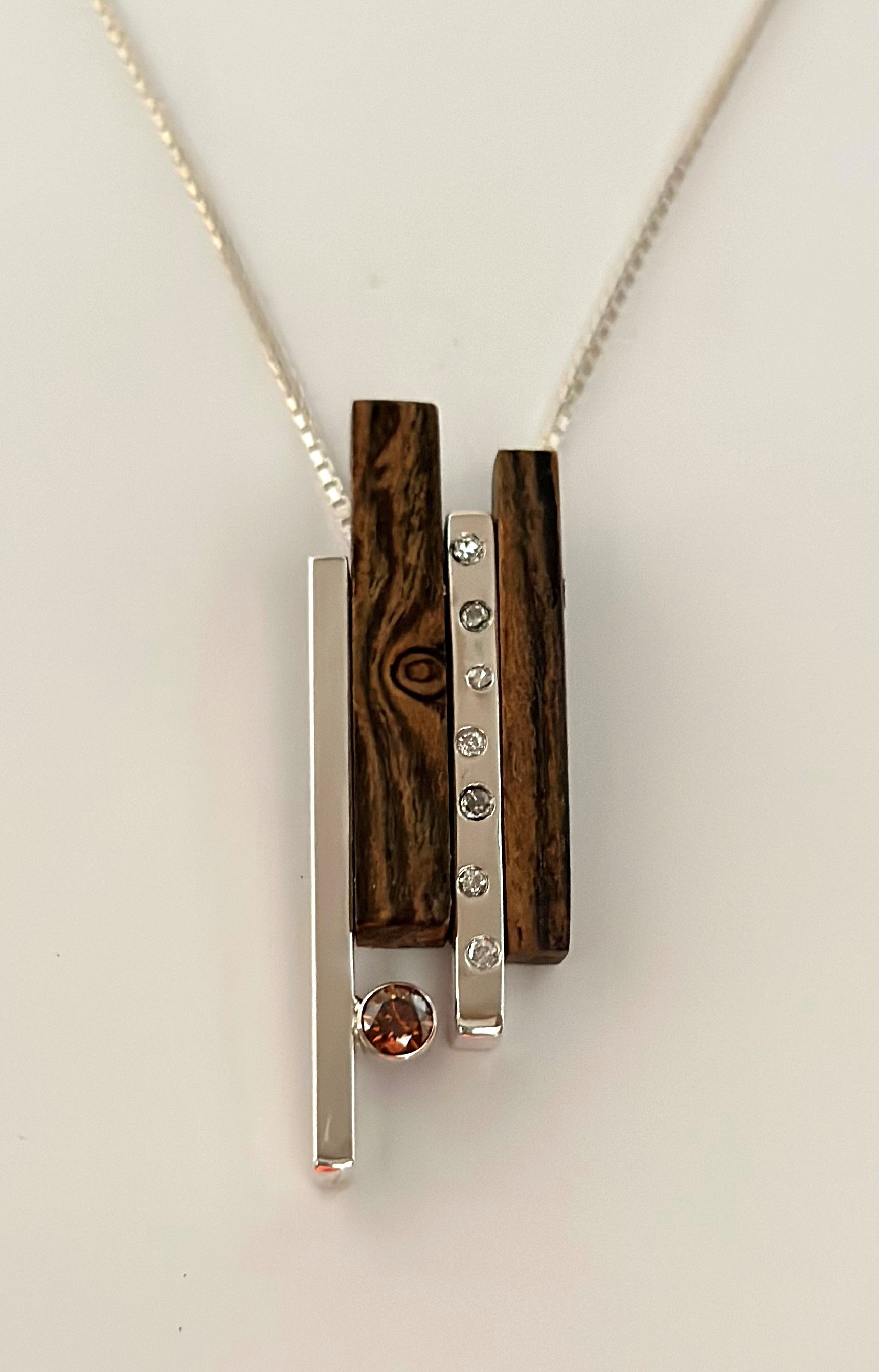  Custom pendant design for a 50th birthday. This pendant has a 1/4 ct cognac round diamond with 7 diamonds to signify a birthday on the 7th of the month. Bocote wood with anti tarnish sterling silver and white gold bezel were used in this pendant.  