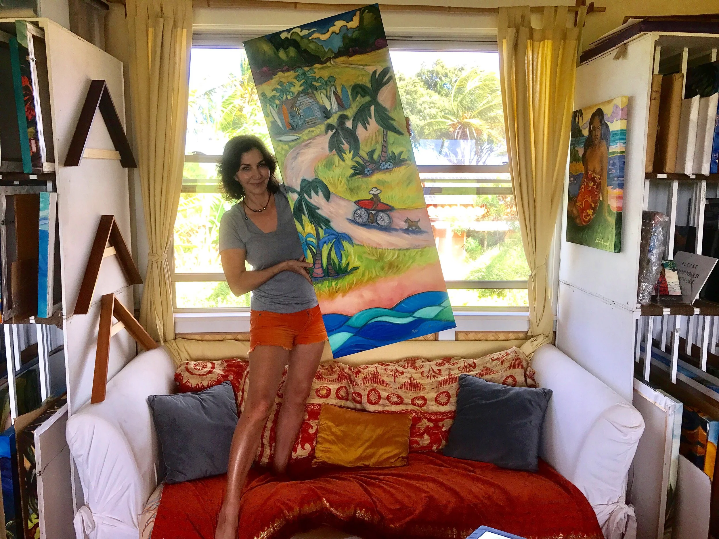  Kim McDonald's Hawaii artist studio — holding a Maui painting 