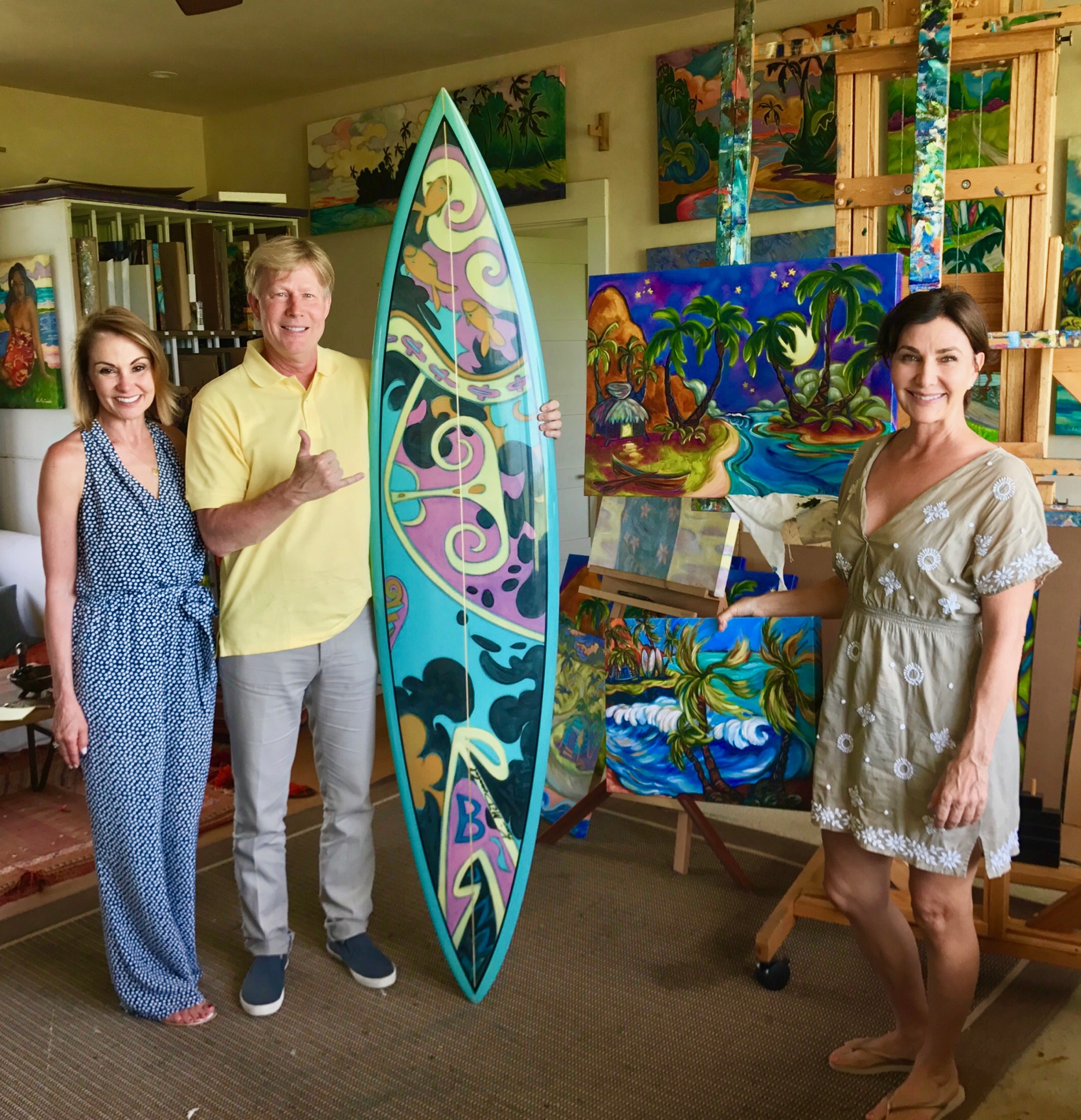 Couple posing with a custom painted surf board and Kim