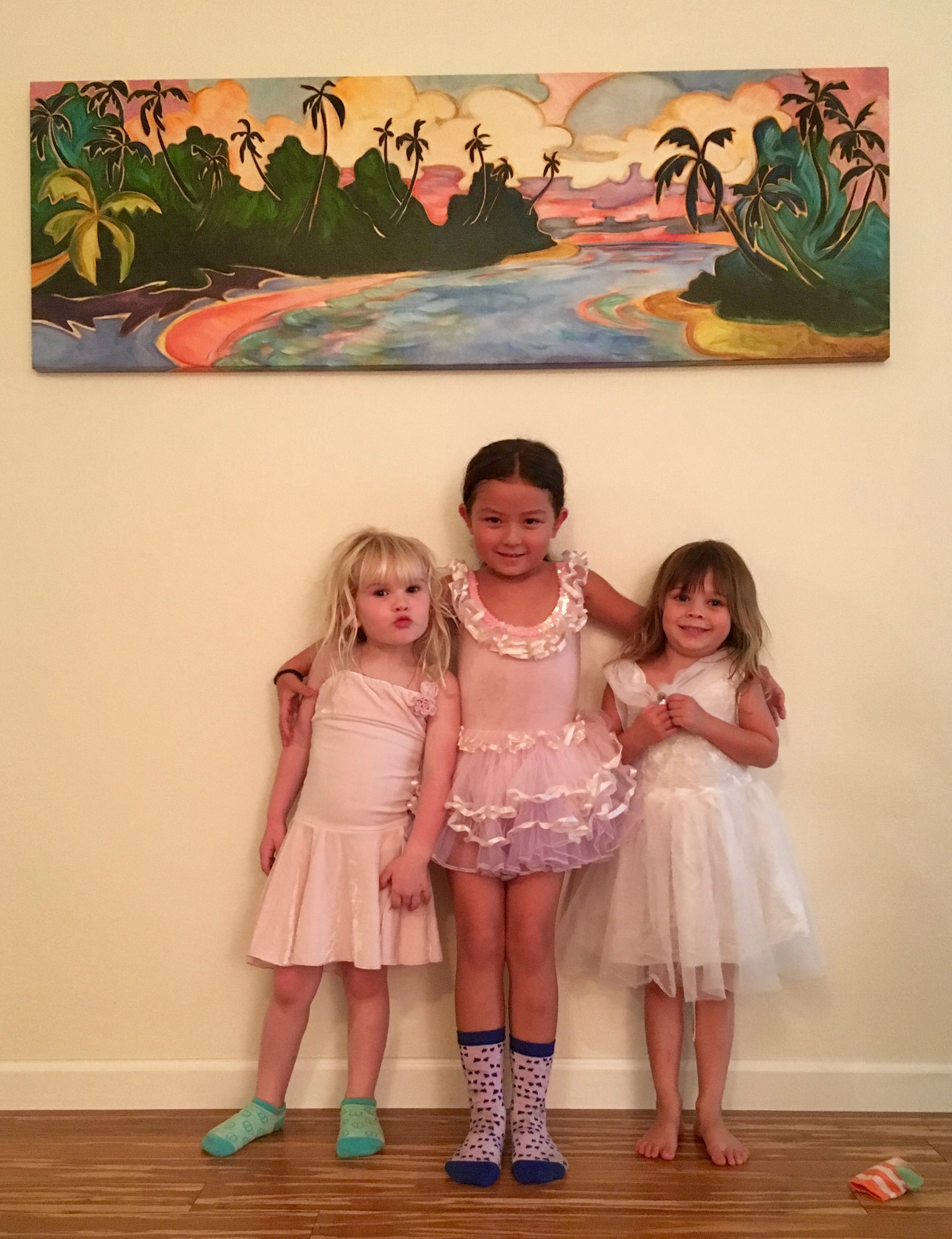 Three little girls posing with an art piece by Kim McDonald
