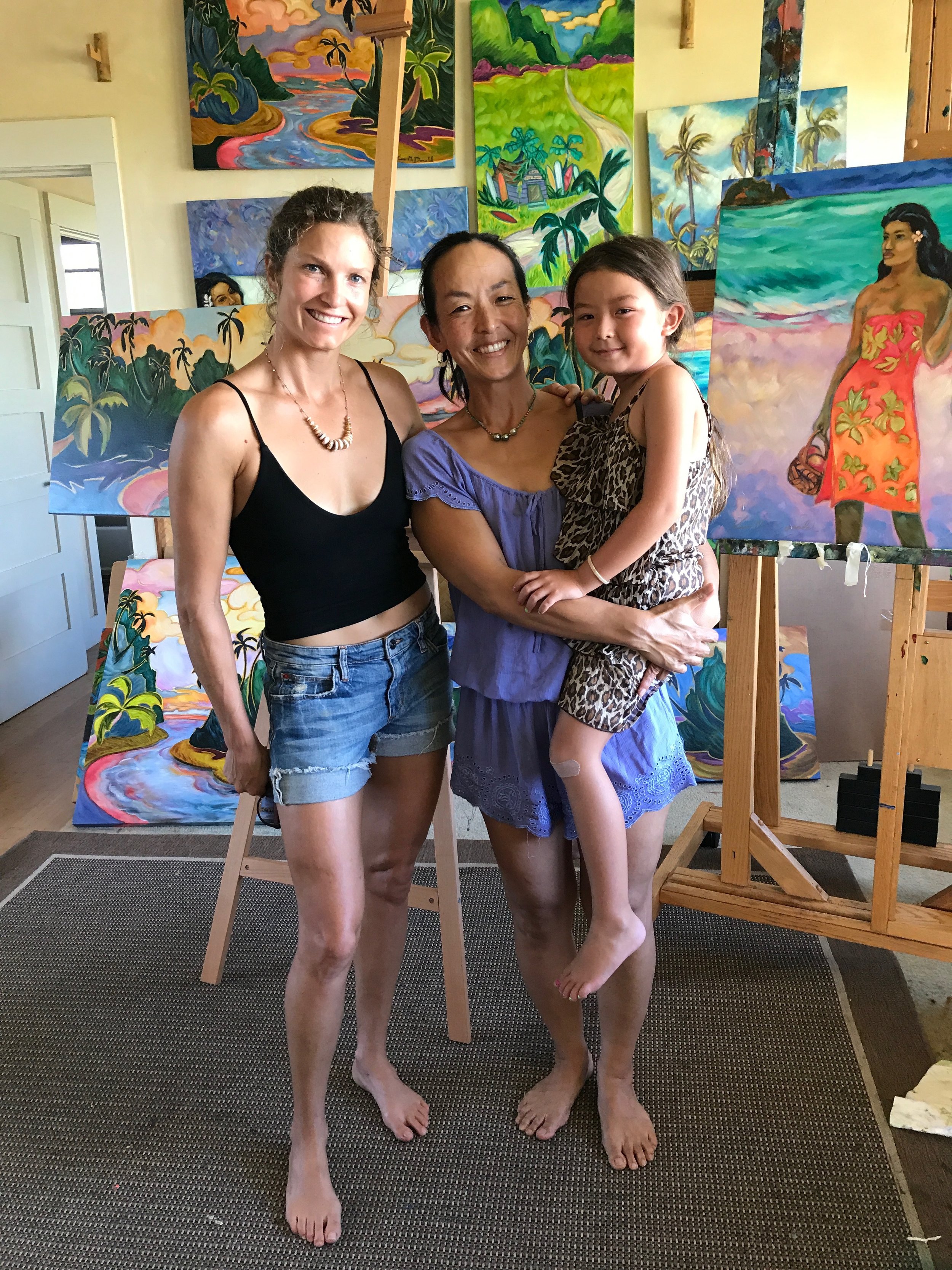 Two women holding a little girl at Kim McDonald's gallery