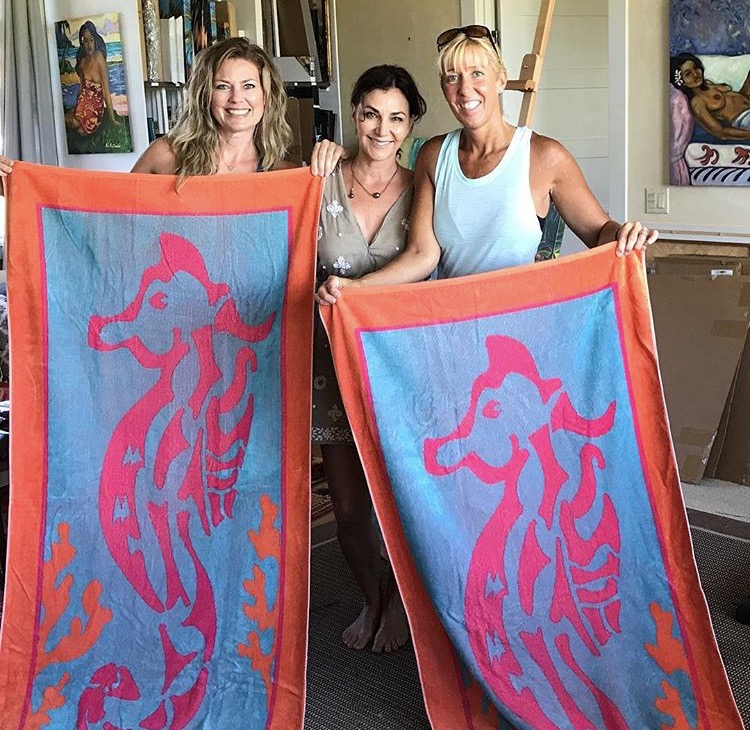 Two women holding up art fabrics with Kim McDonald