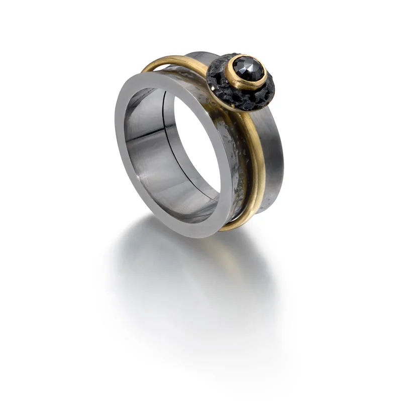 Black rhodium plated silver opening outer ring with 18ct gold moving inner ring with black diamond