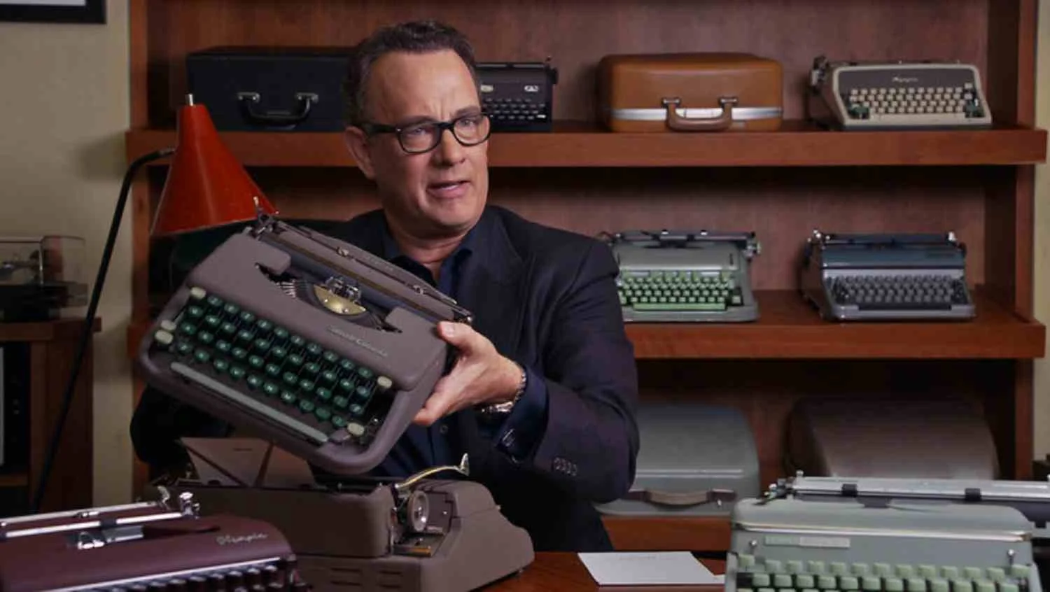 Tom Hanks holds up a typewriter from his collection.