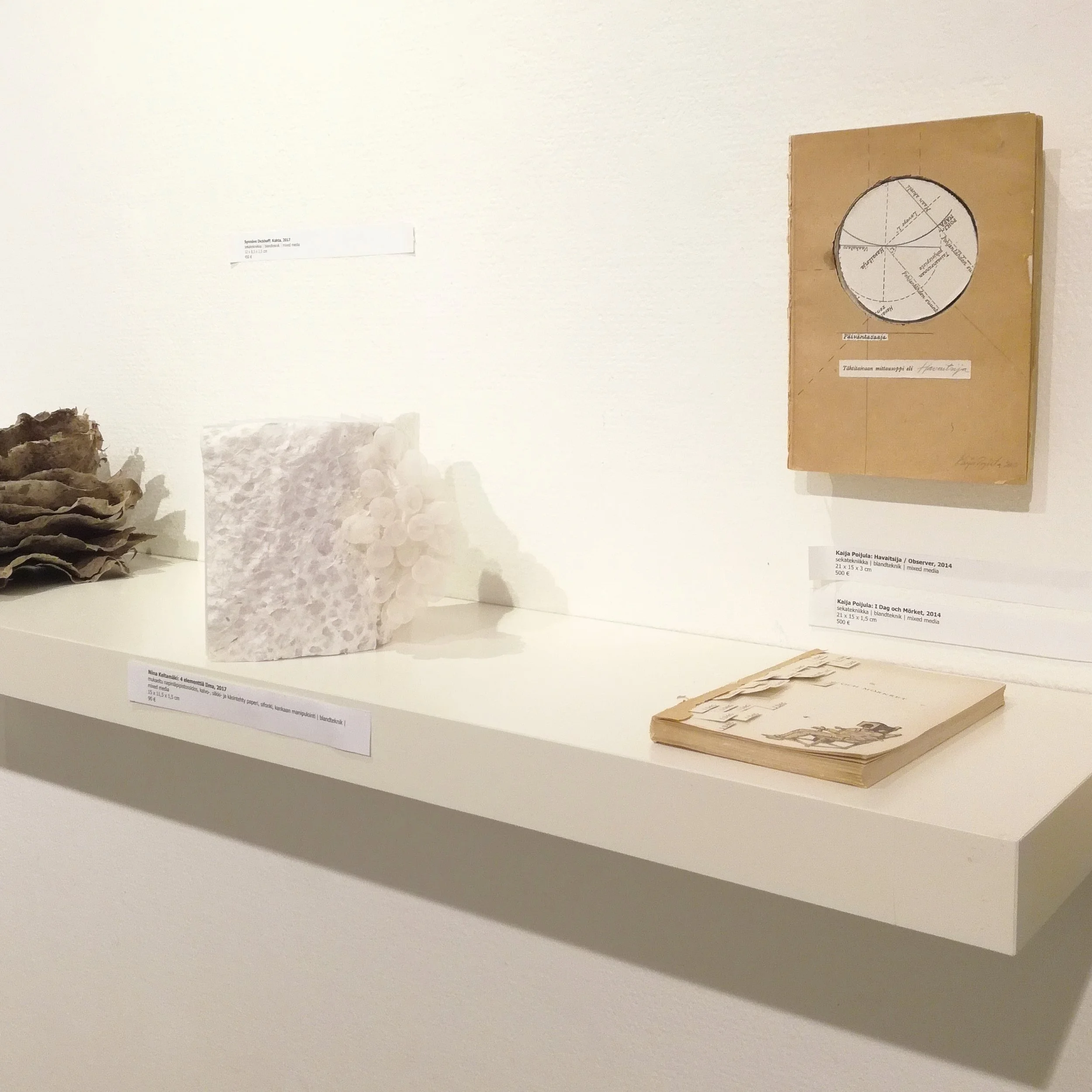4 elementtiä Ilma, 2017, by Niina Keltamäki (left) mixed media - 15x11,5x1,5cm Havaitsija / Observer, 2014, by Kaija Poijula (above) mixed media - 21x15x3cm I Dag och Mörket, 2014, by Kaija Poijula (right) mixed media - 21x15x1,5cm