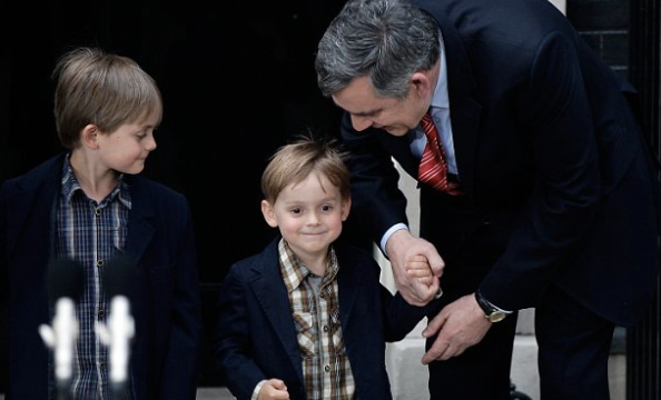 Former PM Gordon Brown holds the hand of son Fraser in 2010 - four years after The Sun put his medical condition on its front page