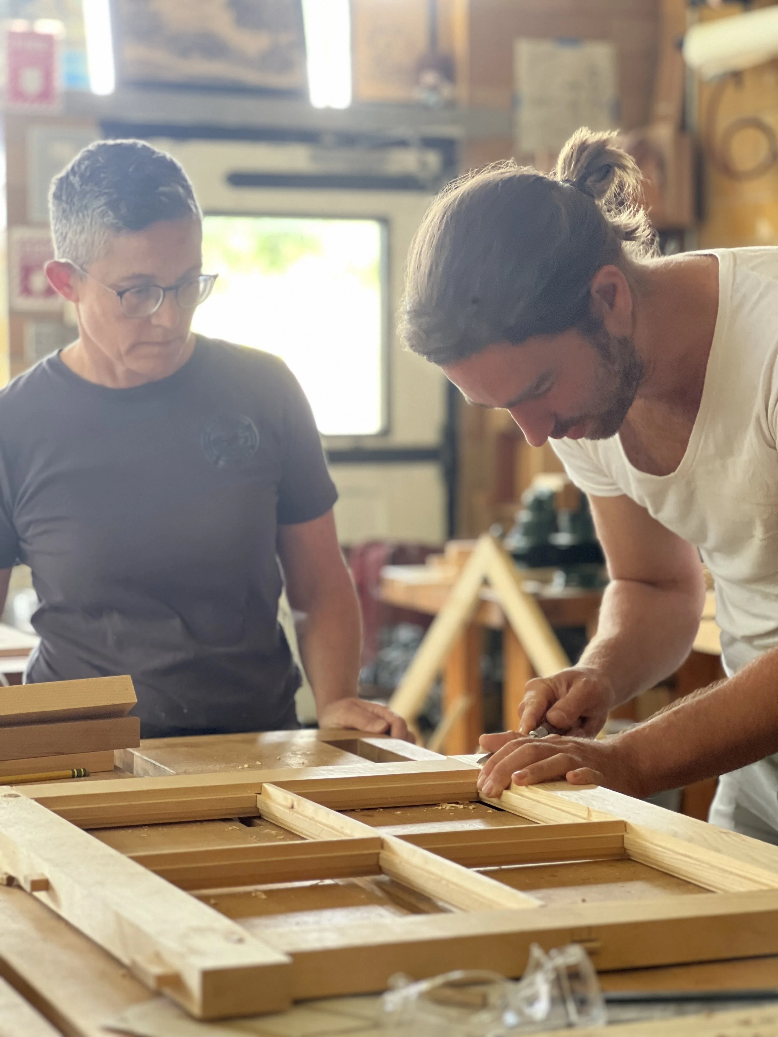 A Man and Woman building sash windows in an Architectural Carpentry & Preservation Program at the Sam Beauford Woodworking Institute.