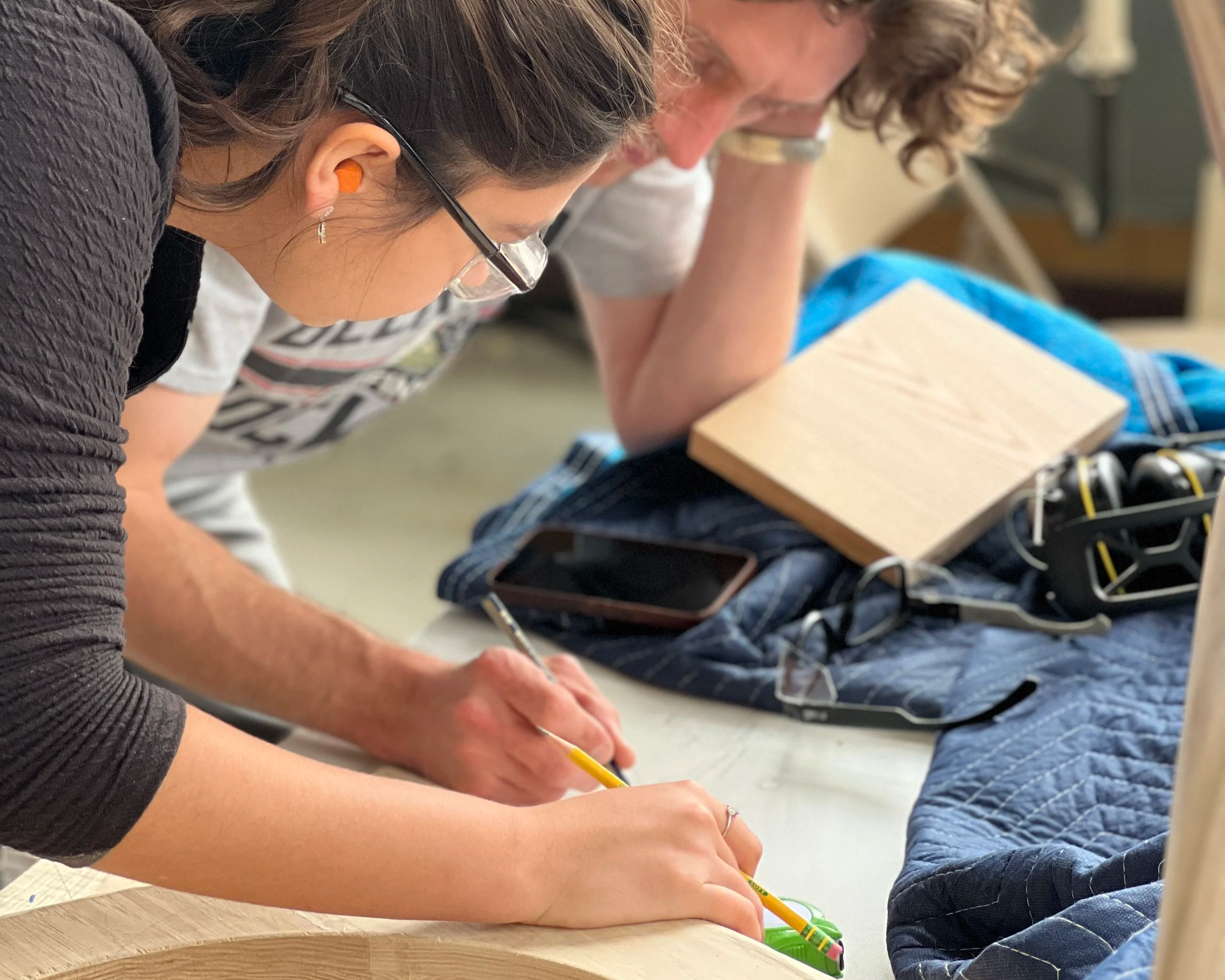 Two trade school students collaborating on a carpentry project