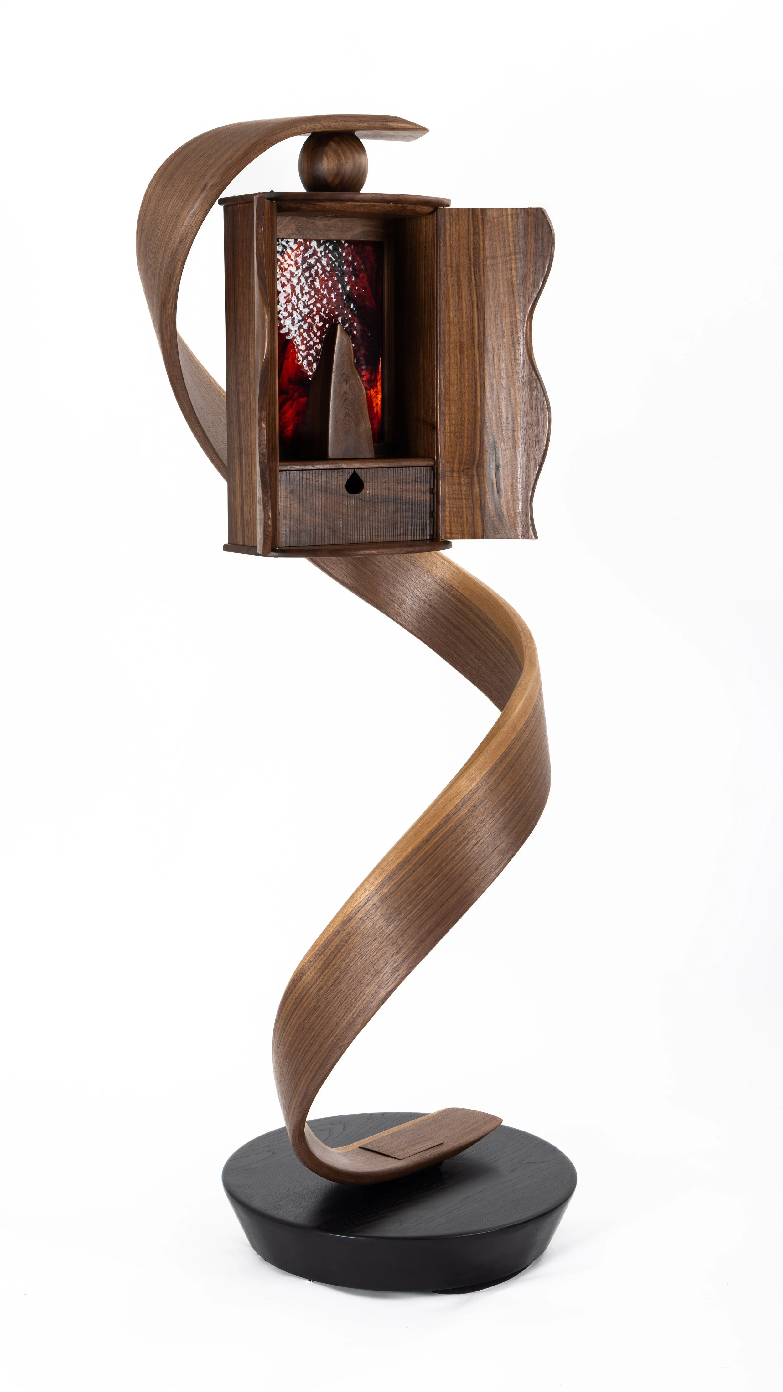A walnut cabinet suspended by a bent lamination spiral that was designed and build by a student at Sam Beauford Woodworking Institute.