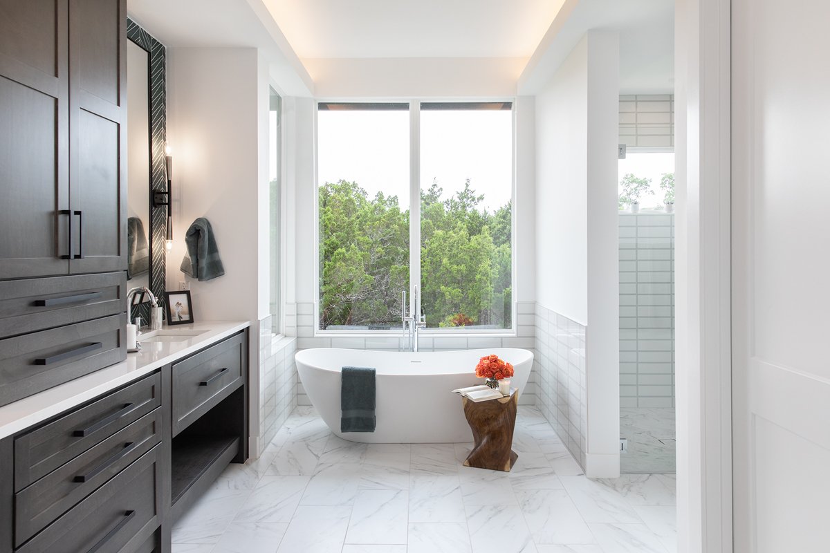 POV: your bathroom feels like a private spa.

A soaking tub with a view of the trees.
Floor-to-ceiling light.
Warm wood tones layered with crisp tile and marble.

Designed for slow mornings, long baths, and a space that feels just as calming as it lo