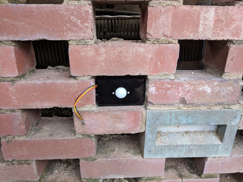 We fabricated acrylic housings for the sensors which nested into the existing perforated brick wall to help conceal them from the light show’s audience. The boxes fit together with finger joint connections and had a large circular opening in the front for the PIR sensor and a smaller one in the back for the wires leading back to the arduinos. The boxes were ultimately sealed with caulking in order to waterproof it and prevent damage to the sensors. We also added a section of 2” pipe in order to narrow the field of view of the sensors to prevent excess triggering of the system. The installation was done on the off-hours of the Conservatory. We placed each sensor box equidistant along the long sides of the Sunken Garden. The wires for each sensor were run behind the garden’s brick walls, while the corresponding Arduino was placed in a waterproof box behind the middles of the brick walls. The power and USB cables were then run behind the walls and above a doorway to a closet where the Mac Mini was placed. There were several instances where we had to revisit the site to make changes, whether it was replacing the Photons with Arduinos, resoldering connections, or checking connections.