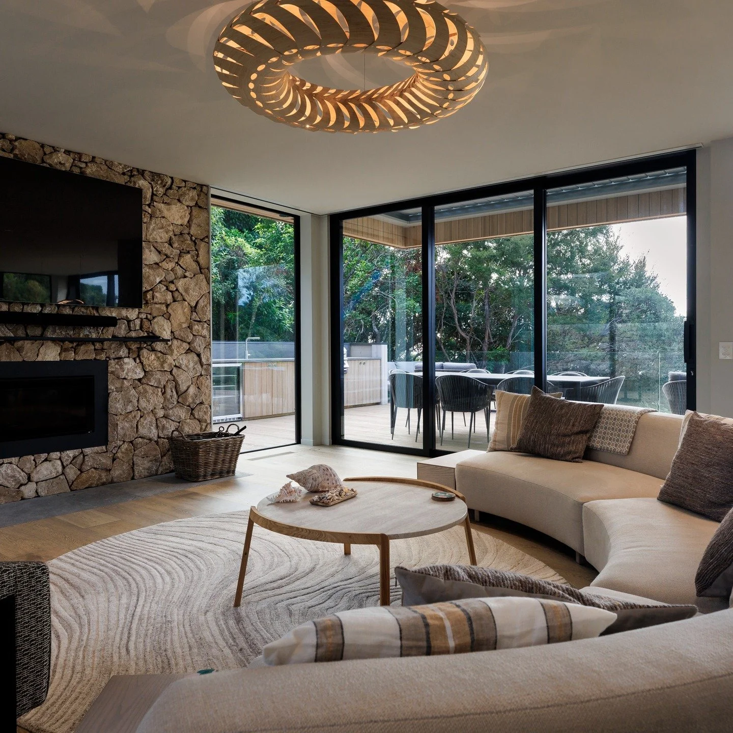 Nestled into the bush, with a view to the picturesque bay below, the living spaces of this holiday home bring an instant calmness. @ecooutdoor Freeform Canyonfell stone features alongside the @davidtrubridge 'Maru' pendant

#architecturenz #nzarchite