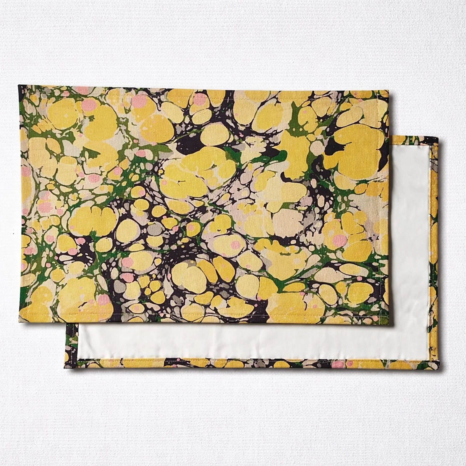 Elegant table setting with marbled placemats in green and gold tones, Italian artisan table decor