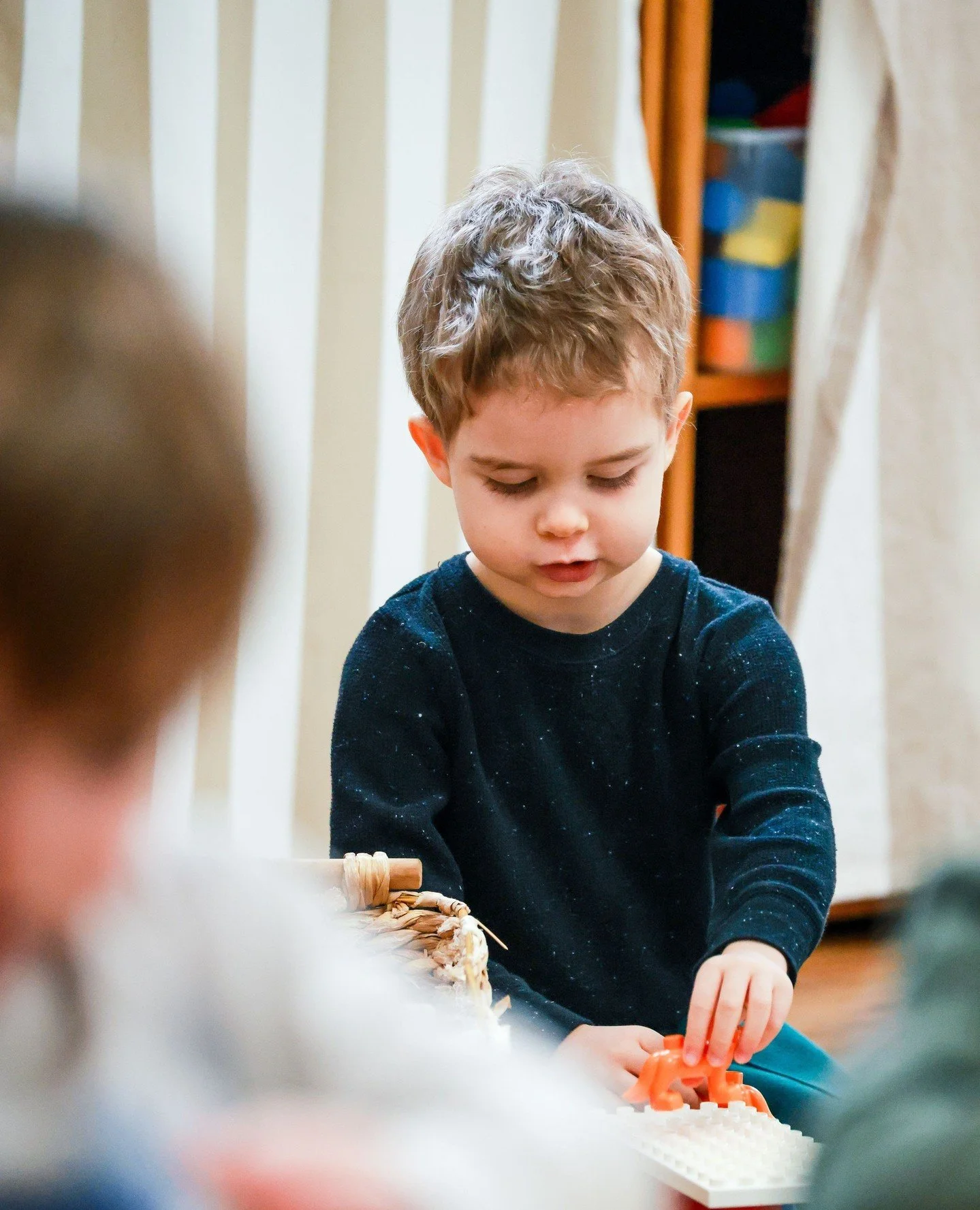 Low, accessible shelves, organized by type, encourage independent, child-led play.