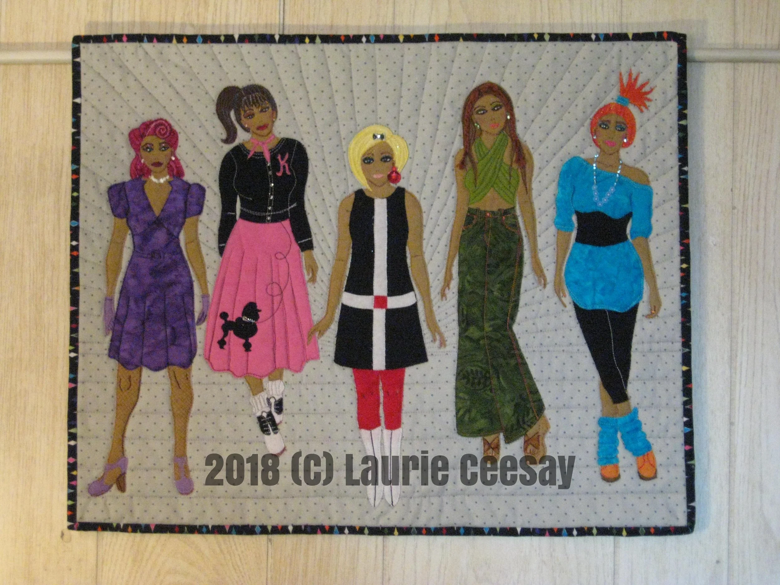 I entered in the International Mini Quilt Exchange from The Quilt Show website sponsored by Alex Anderson and Ricky Timms. The point of the challenge was to pair a quilter from the US with an international quilter, make a mini version of a quilt with size requirements, each have a year to bond with each other through the year on email and social media, each meet the deadline of the contest then the judges select teams which then travel across the country to quilt shows. The quilts that are not selected will then be exchanged among partners. In theory this sounded great but my story did not pan out this way. I was paired with a quilter from Canada who is a professional long arm quilter and teaches on quilt cruises. We befriended each other on Facebook and then communication stopped. I have no disrespect for Canada but I was hoping to be paired up with a quilter from across the globe AND perhaps gain a new quilter friend. I could drive to Canada if I wanted to thus not a huge different from Upper Michigan where I live. This partner made no contact with me on FB until about 3 months before the deadline date to see if I was still interested in the quilt exchange-I said yes. I completed the quilt seen in the first photo and entered the contest. I notified my partner on FB that I did so. I never heard from her. The judges selected their winning teams. I found out my partner had never entered her quilt. I was disappointed. I contacted her on FB and found out she had personal issues and she did not start the project. I told her I would keep my quilt. What is the lesson learned-to just stick to myself and not be paired up with a stranger that you can not depend on. So let's talk about the quilt!! It is 18" x 24" inspired by a paper doll book I own. I made 5 "dolls" representing hair and fashions from the 1940s through the 1980s. It was all very "mini" in size but it was fun to challenge myself to create on a small scale.